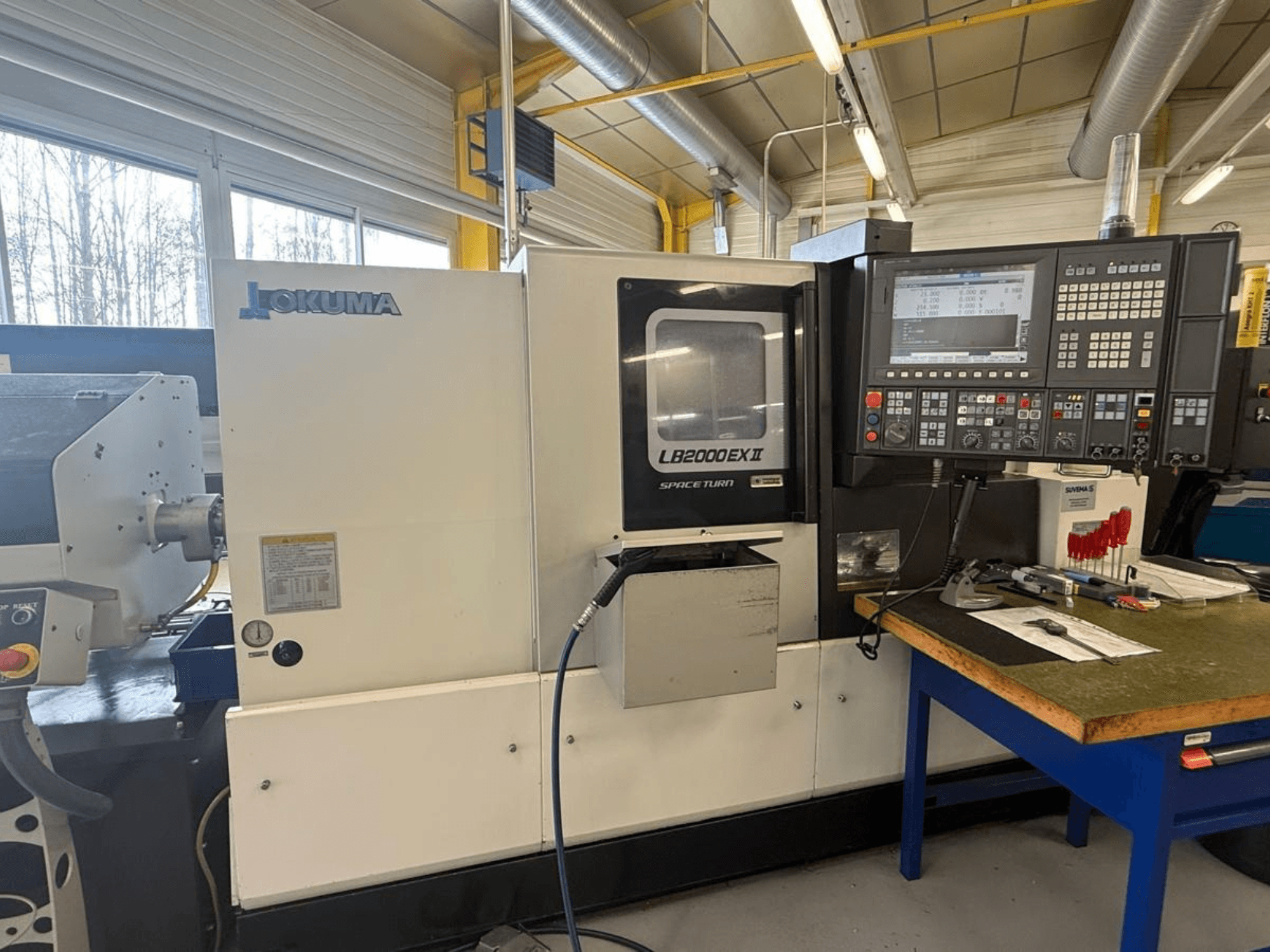 Горизонтальний токарний верстат Okuma LB2000EX II, вид спереду; показує панель керування, зону шпинделя та навколишній робочий простір.