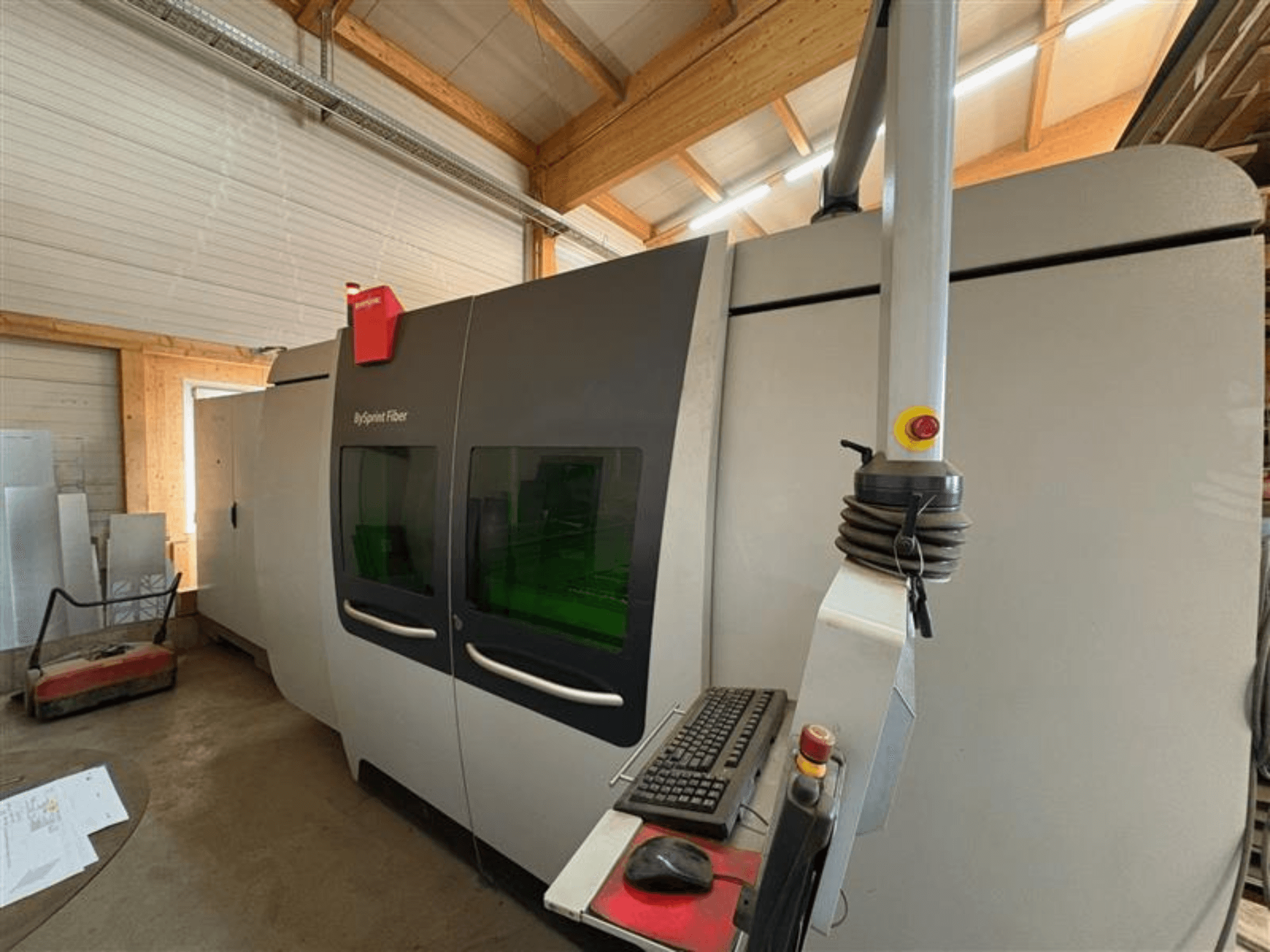 Верстат для різання волокон Bystronic ByJet у майстерні, вид спереду з панеллю керування та двома зеленими оглядовими вікнами.