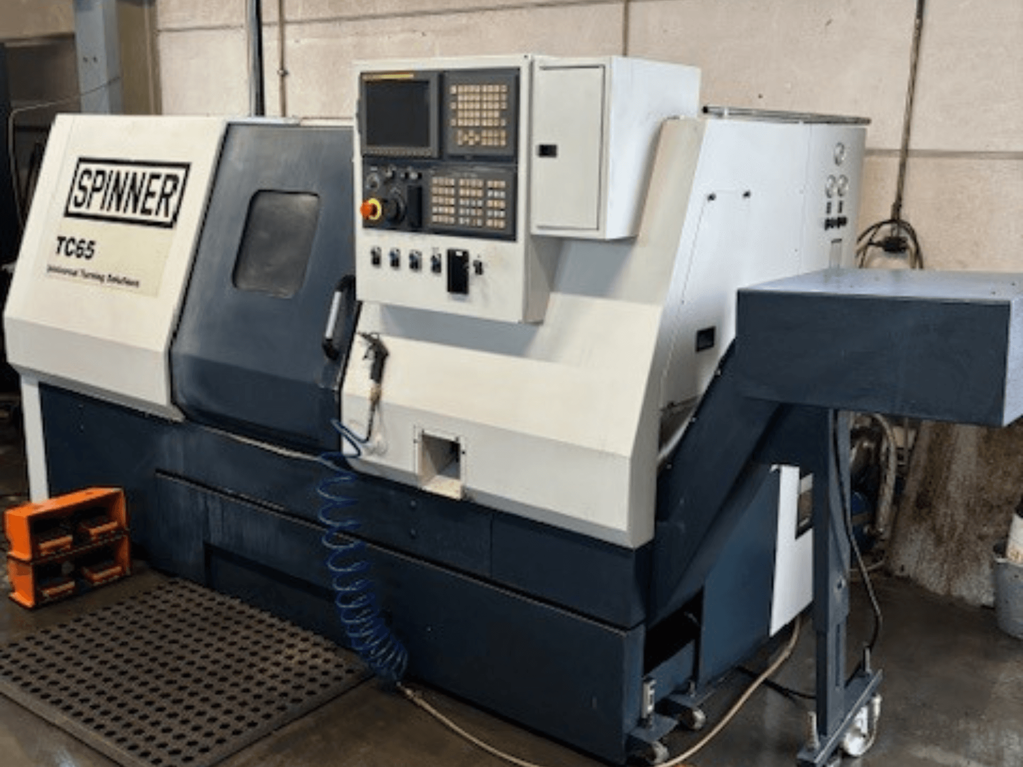 Промисловий токарний верстат Spinner TC65, вид спереду, з панеллю керування, підведенням стисненого повітря та місцем для зберігання інструменту.