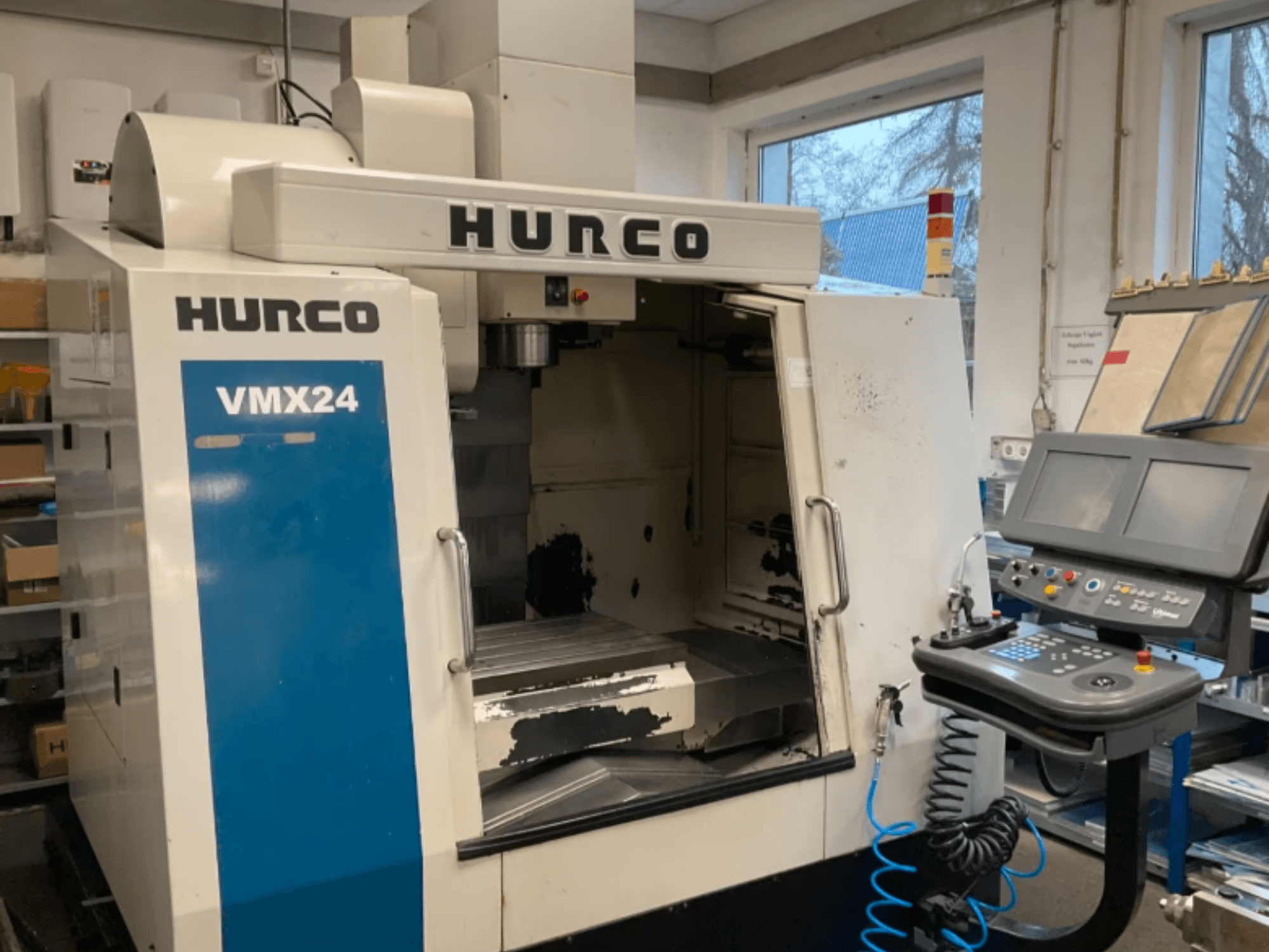Вертикальний обробний центр Hurco VMX24 у фронтальному ракурсі: на фото видно панель управління, шпиндельну головку та робочу зону, а також деякі сліди зносу.