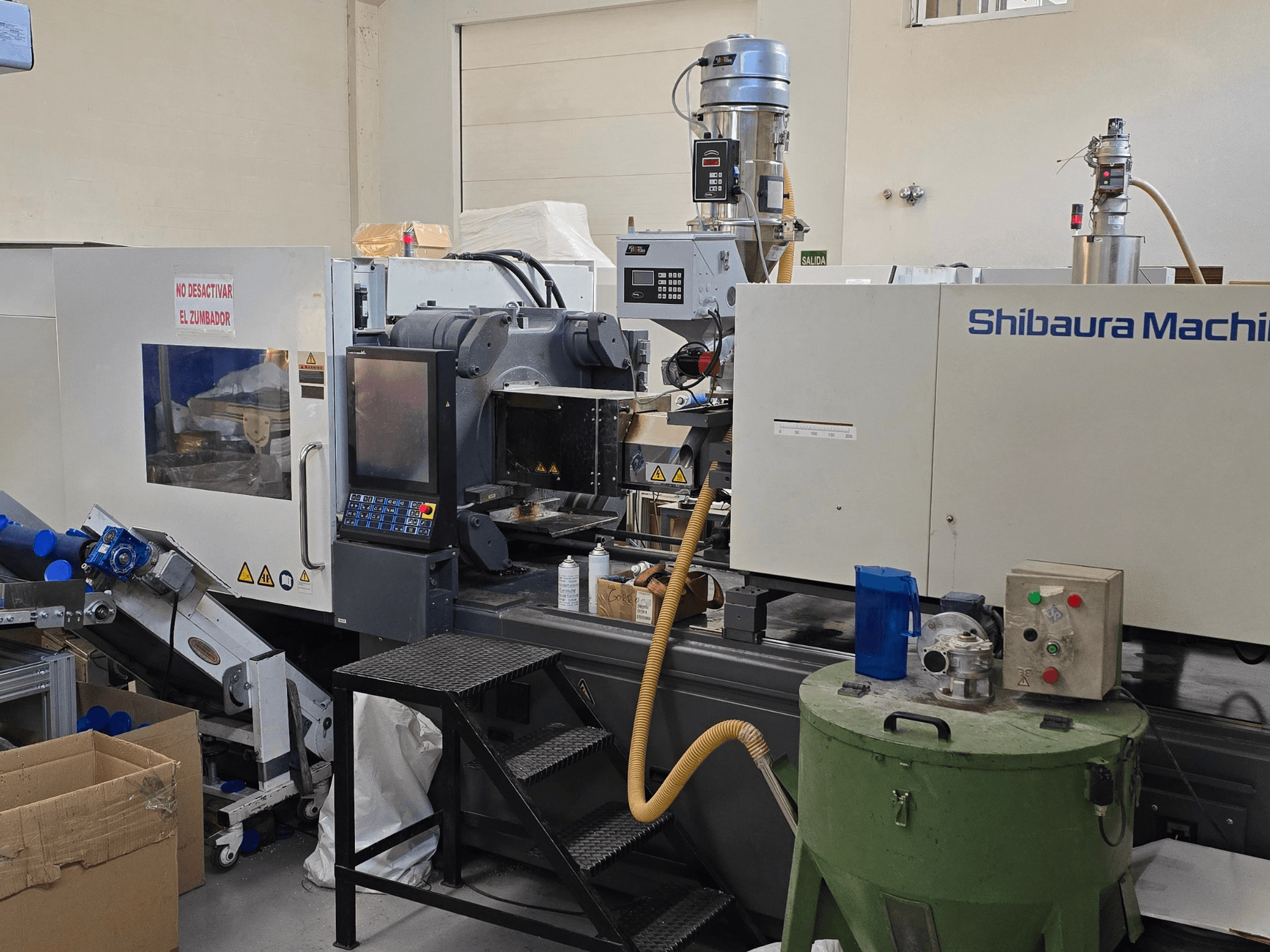 Вид спереду на термопластавтомат SHIBAURA EC230SXIII-8A з панеллю керування та суміжним обладнанням.