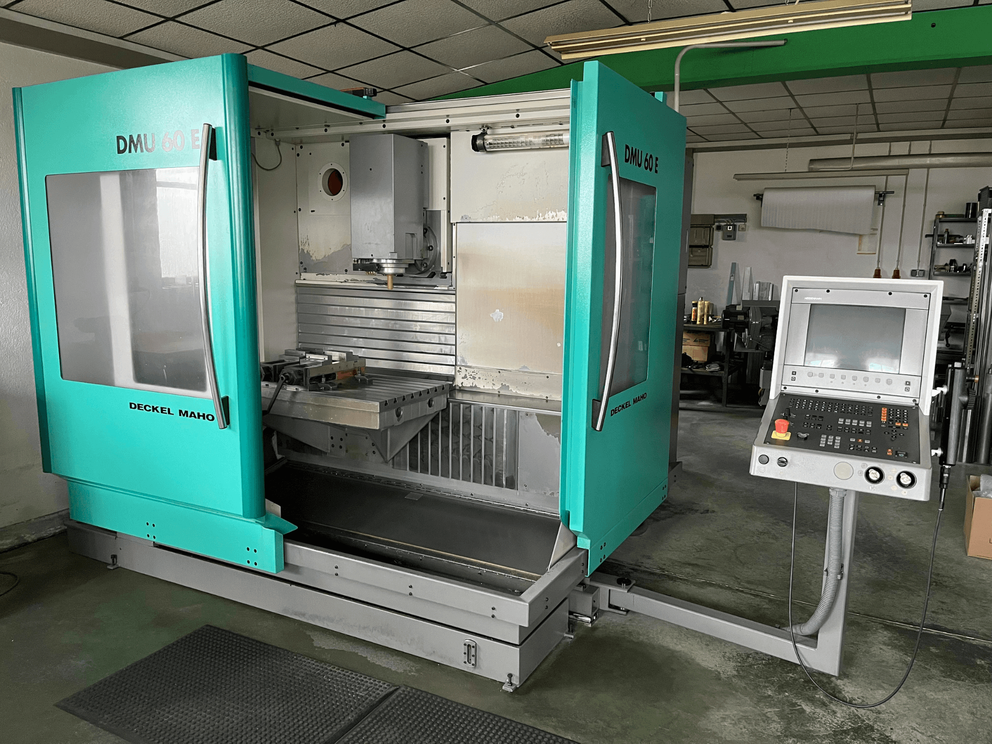 Вертикальний обробний центр DECKEL DMU 60 E у вигляді спереду, демонструє панель керування та шпиндельну головку для точної обробки.