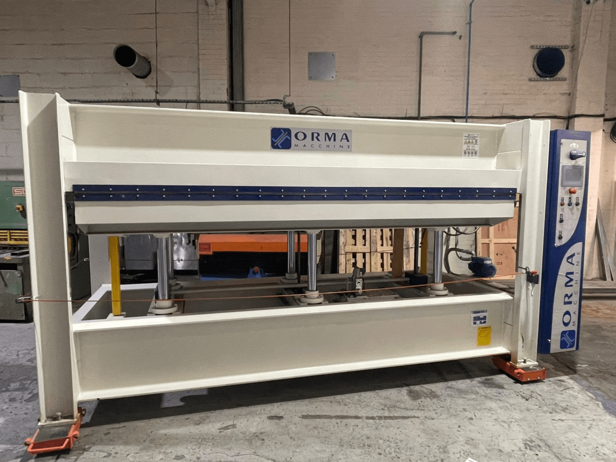 Гідравлічний прес ORMA machinery, вид спереду, зі сріблястим покриттям, з панеллю керування праворуч і вертикальними поршнями для пресування.