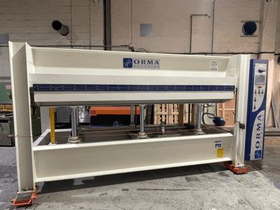 Гідравлічний прес ORMA machinery, вид спереду, зі сріблястим покриттям, з панеллю керування праворуч і вертикальними поршнями для пресування.