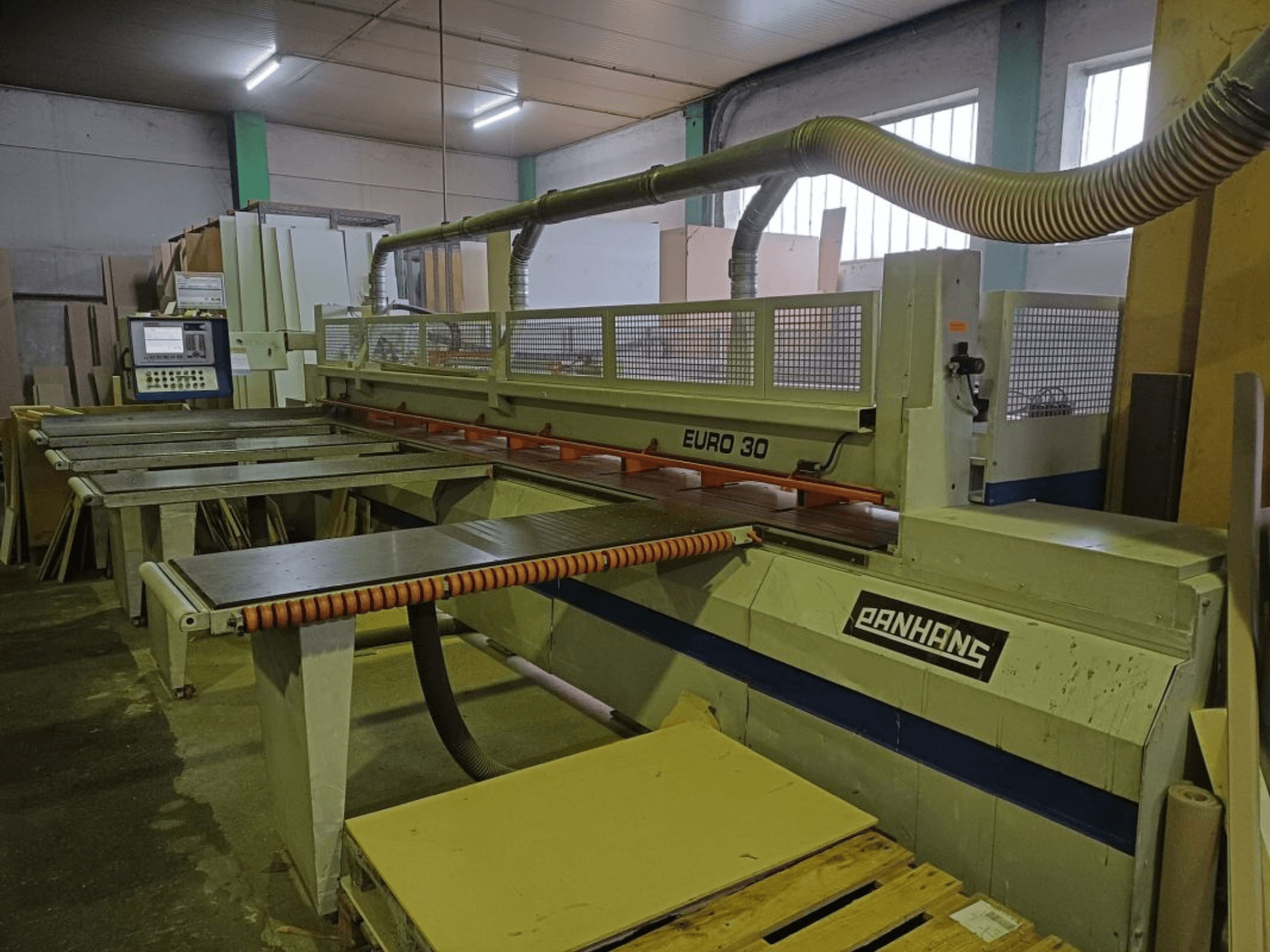 Вид спереду панельної пилки PANHANS EURO 30 з панеллю керування, ріжучим столом і шлангом для відсмоктування пилу в умовах майстерні.