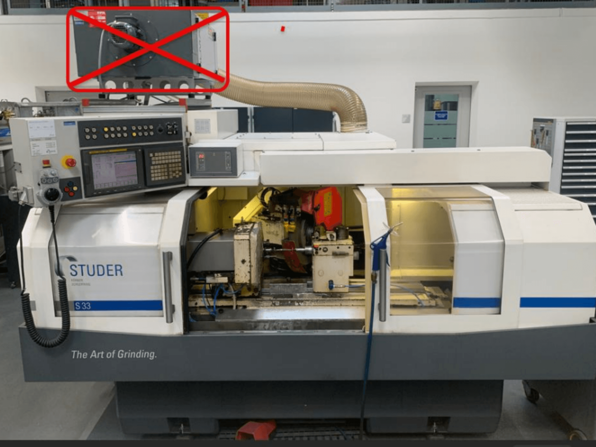 Круглошліфувальний верстат Studer S33, вид спереду з панеллю керування та шліфувальними компонентами з видимими електричними з'єднаннями.