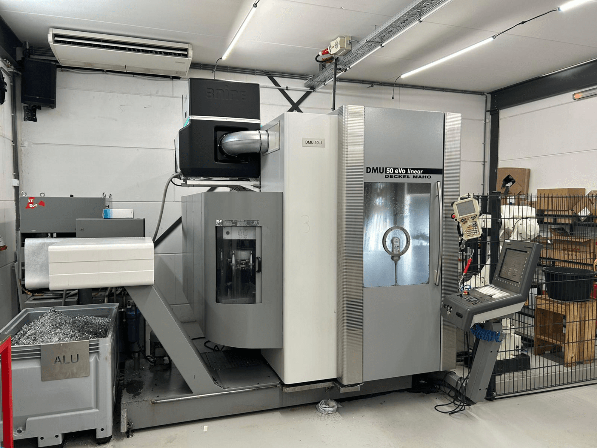 Лінійно-фрезерний верстат DMU 50 eVo від Deckel Maho, вид спереду, з панеллю керування та контейнером для стружки.