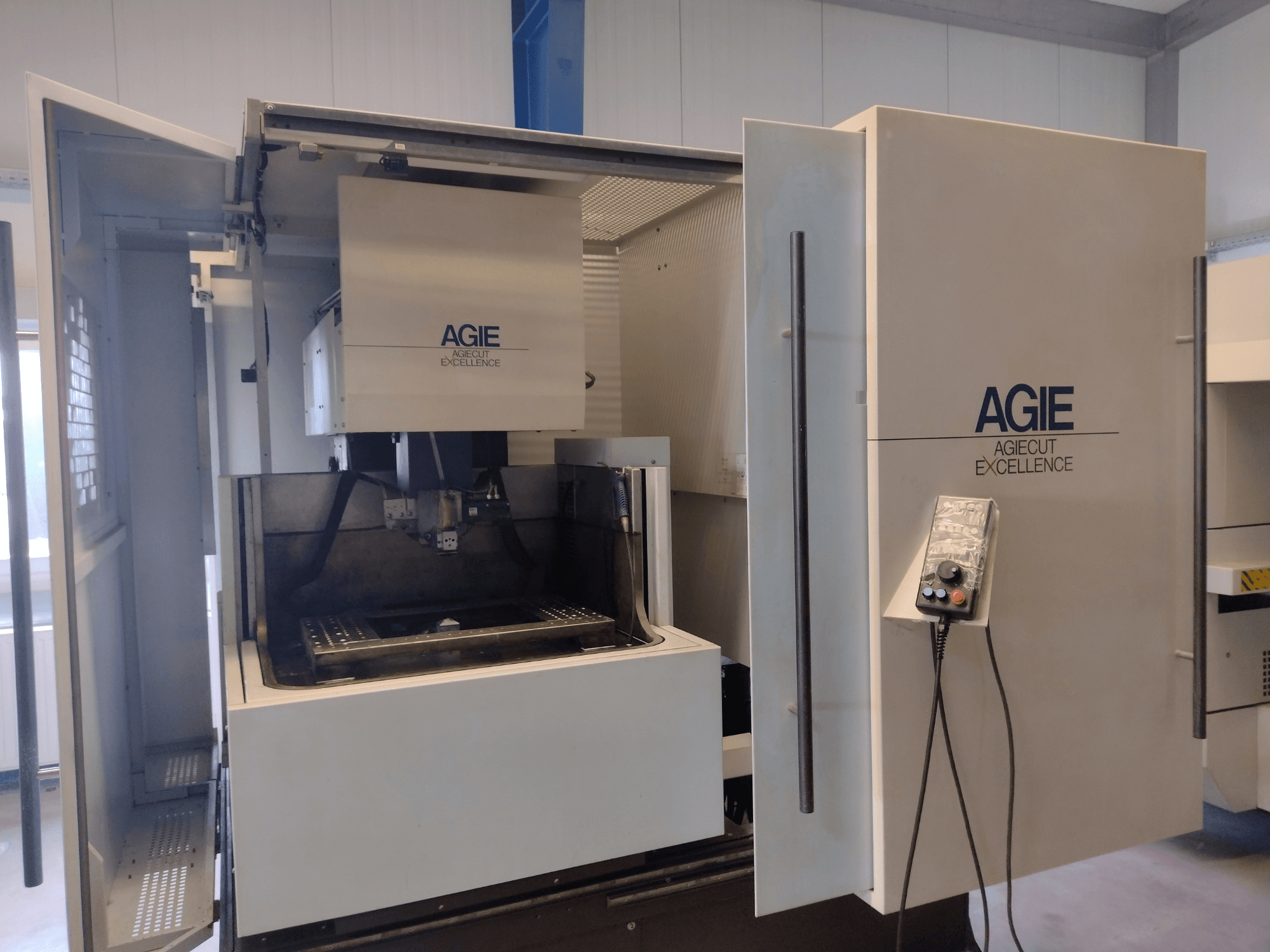 Електроерозійна машина AGIE Progress 3 Wire у фронтальному ракурсі, з відкритим корпусом, панеллю керування та зоною різання.