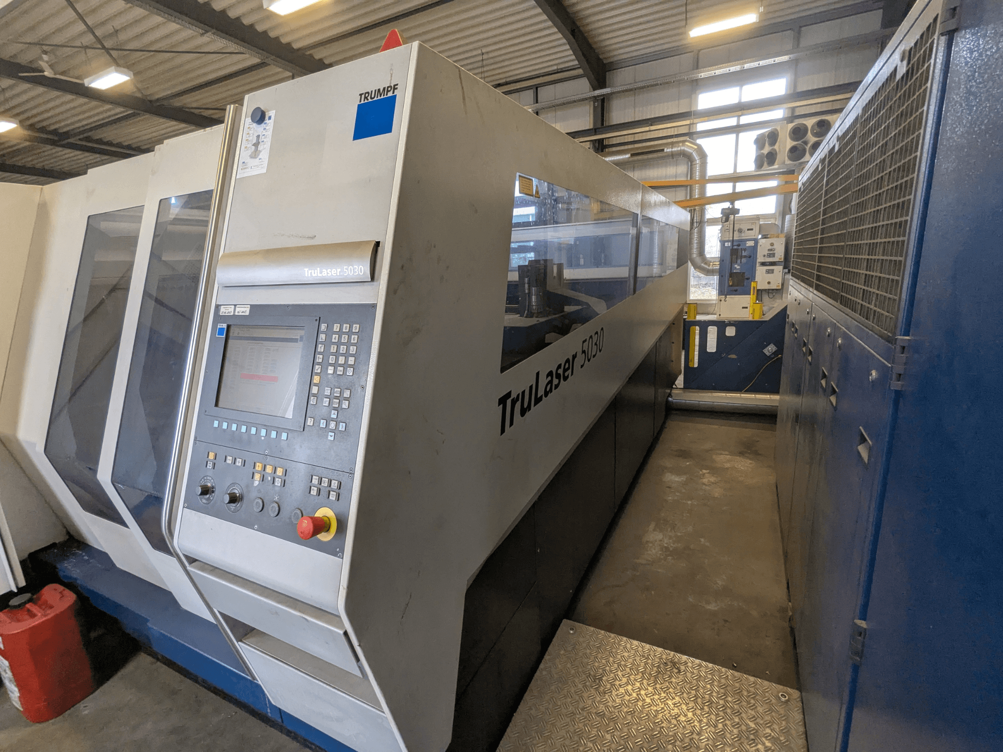 Машина для лазерного різання CO2 TRUMPF TruLaser 5030, вид спереду з панеллю керування та елегантним дизайном, в промислових умовах.