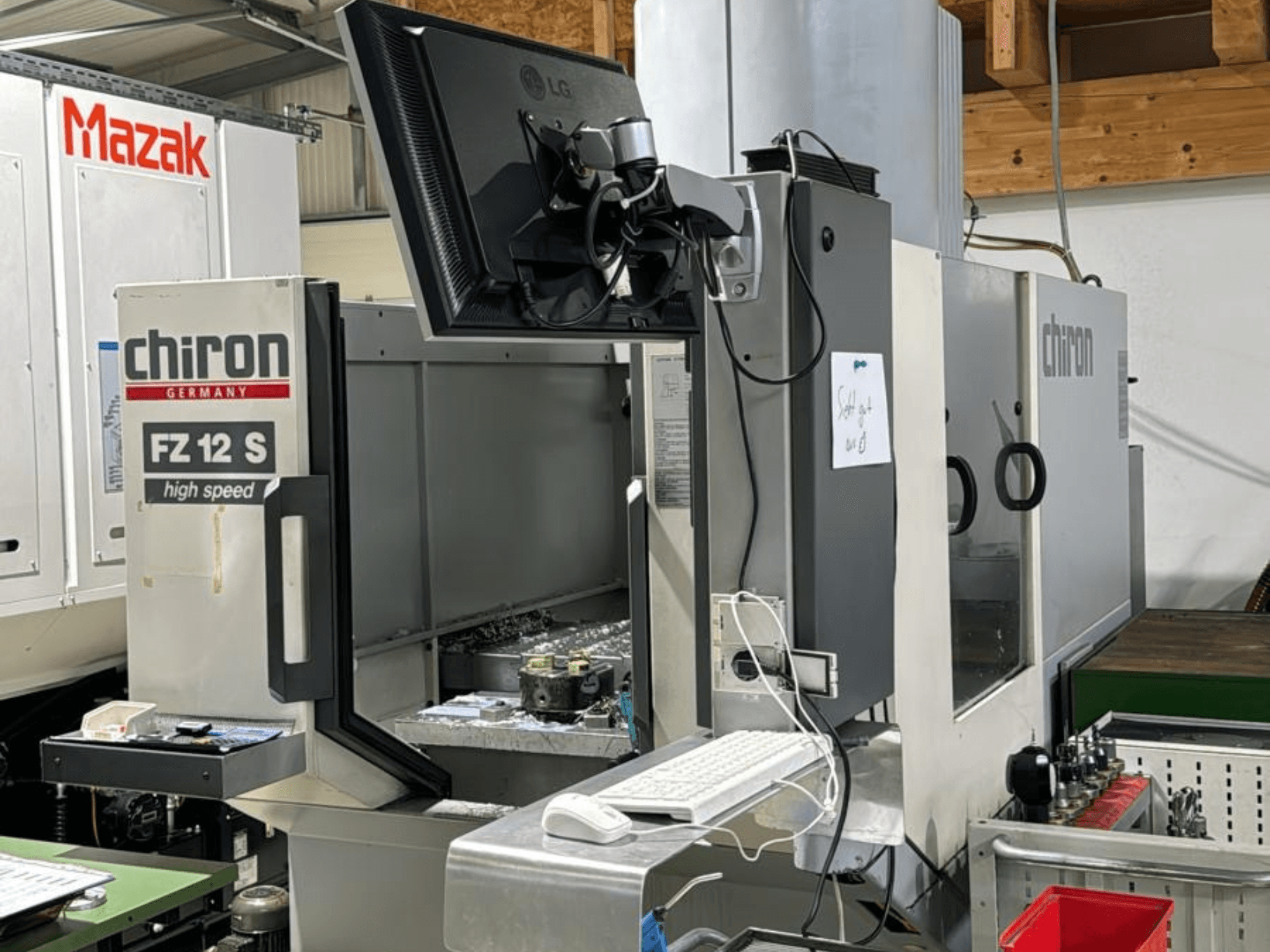 Вертикальний вид високошвидкісного обробного центру CHIRON FZ 12 S з контрольним екраном і відходами від процесу обробки.