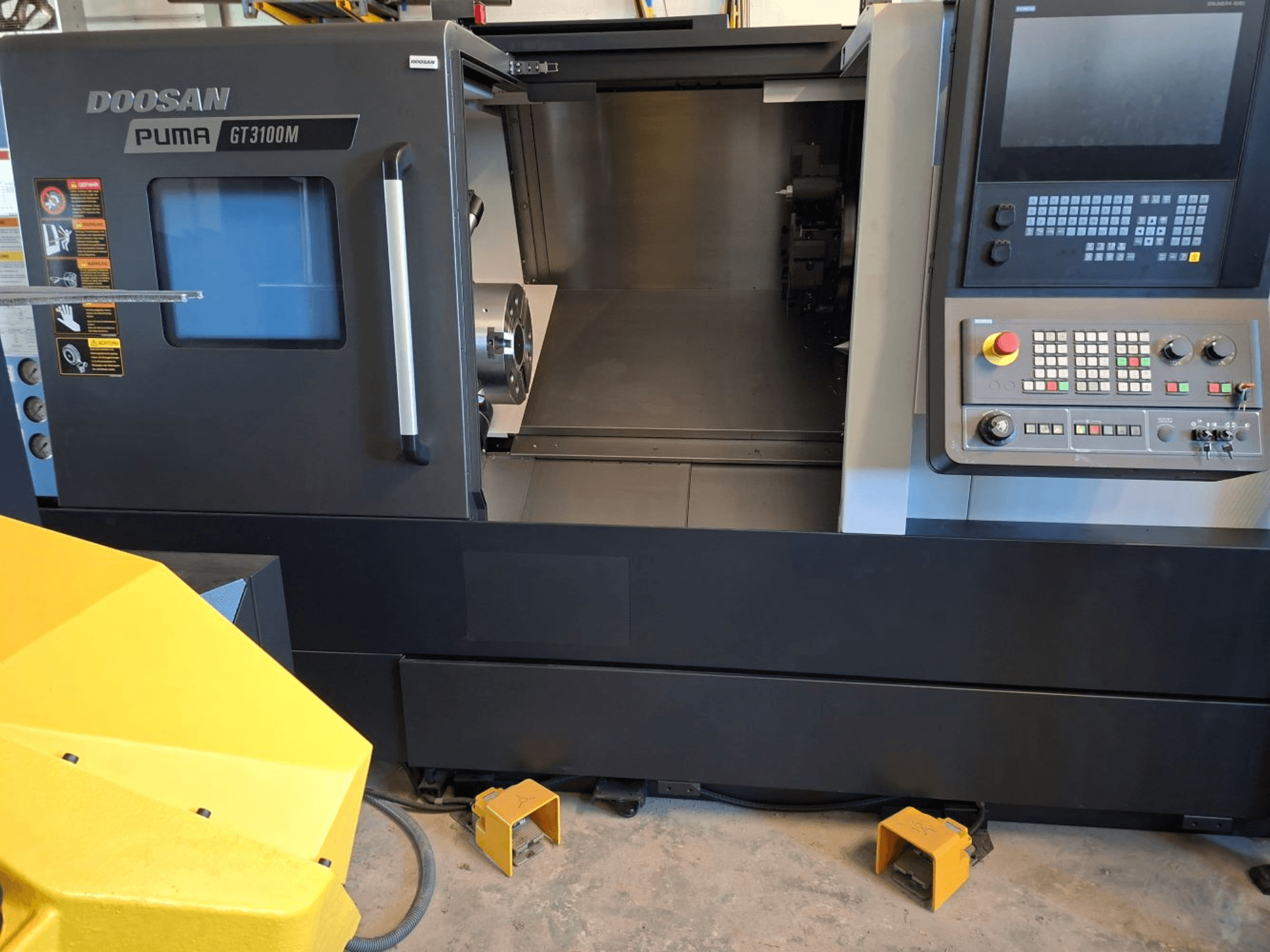 Горизонтальний токарний верстат DOOSAN Puma GT 3100 M спереду, демонструє панель керування, відкриту револьверну головку та внутрішній робочий простір.