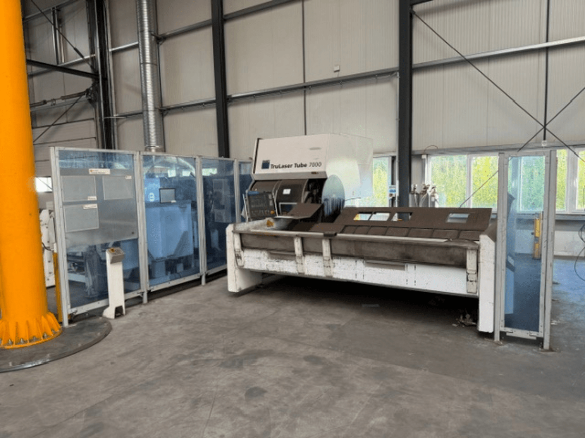 TruLaser Tube 7000 від компанії TRUMPF — вид спереду на верстат для різання труб у добре освітленому промисловому приміщенні, на якому видно елементи управління.