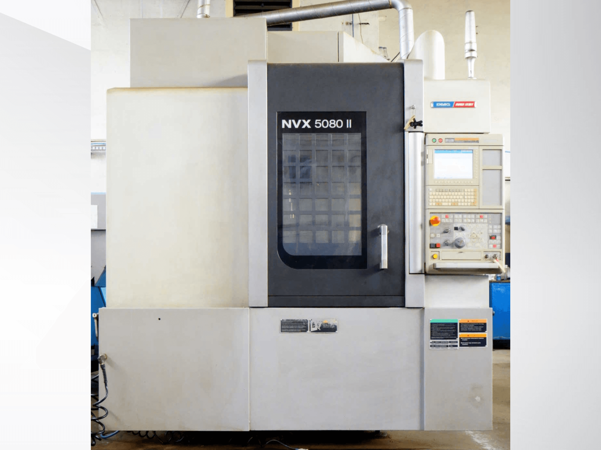 Вертикальний обробний центр DMG Mori Seiki NVX 5080 II, вид спереду, з панеллю керування та решітчастими дверцятами.