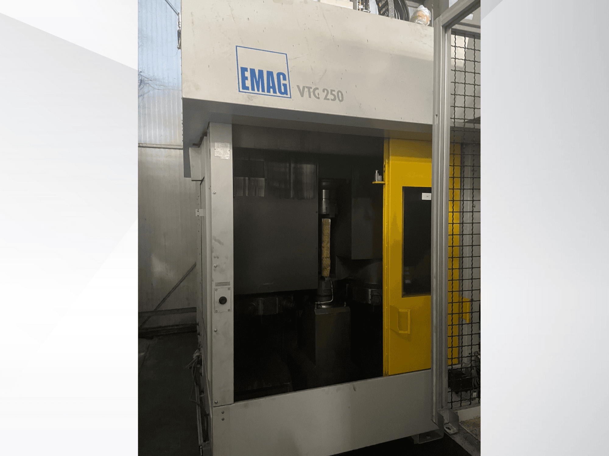 Вертикальний обробний центр EMAG VTC 250 спереду, з жовтими дверцятами та видимим ріжучим інструментом всередині камери.