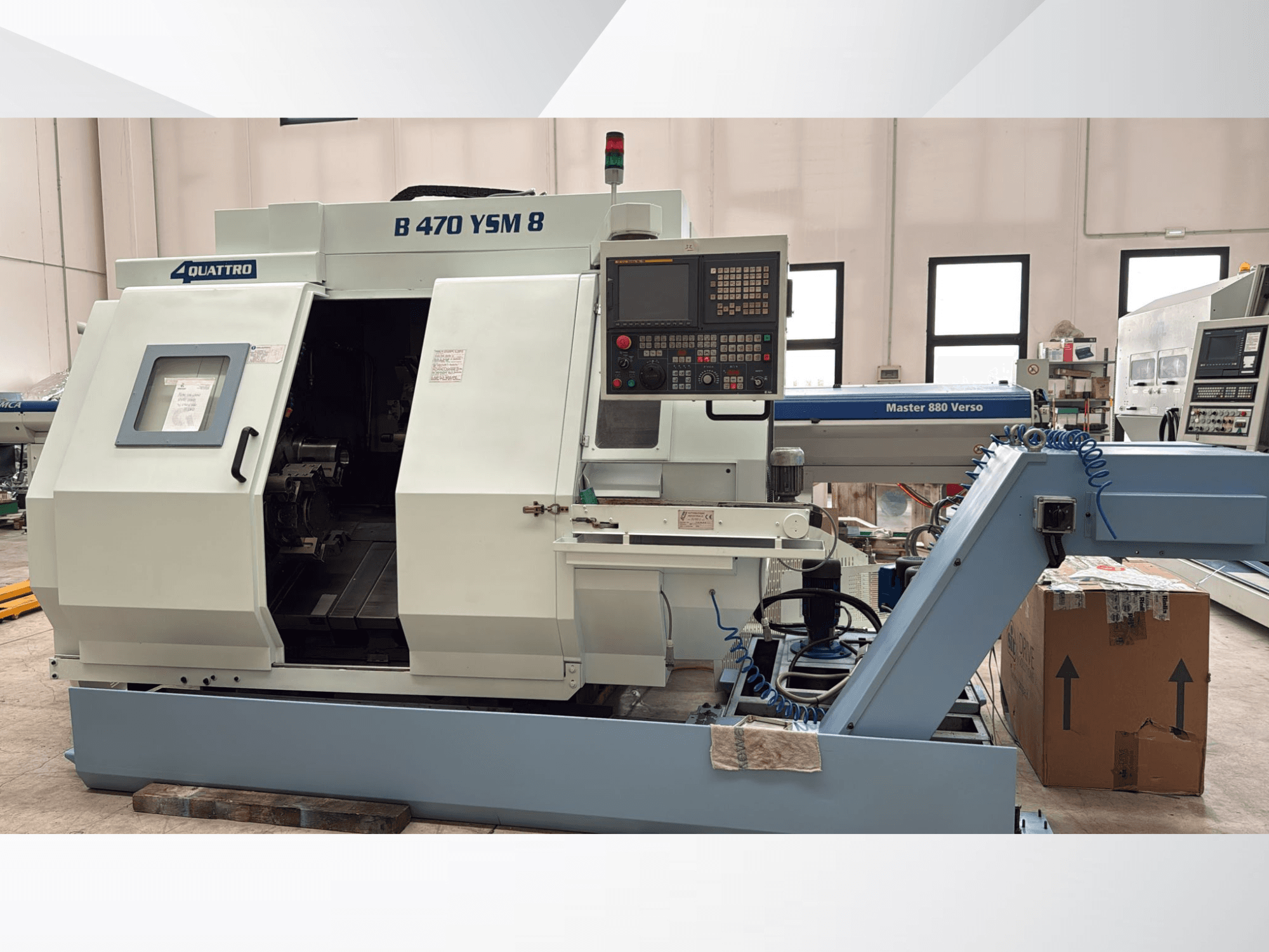 Токарно-фрезерний центр Biglia B470 YSM, вид спереду з панеллю керування, відкритим люком і робочим простором з інструментами всередині.