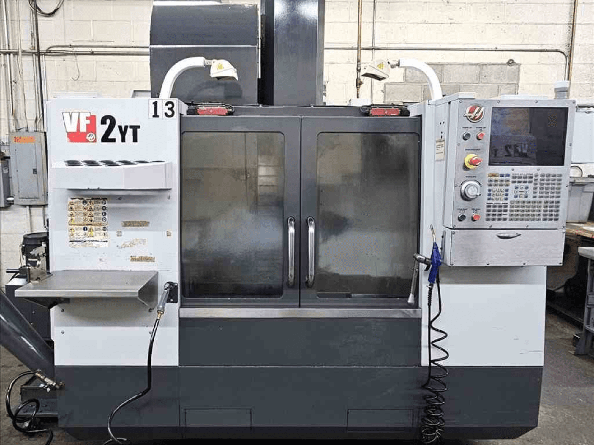 Вид спереду вертикального обробного центру HAAS VF-2YT, з панеллю керування та скляними дверцятами.