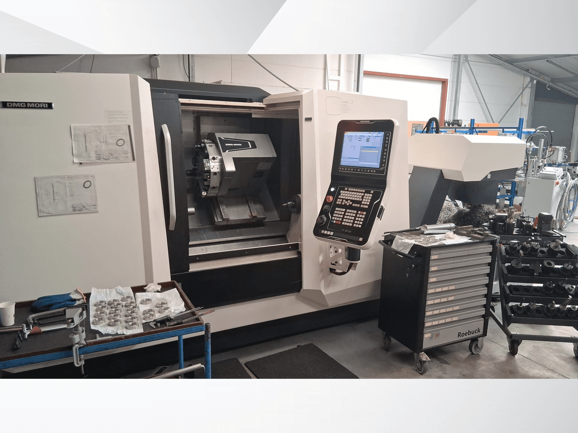 Горизонтальний токарний верстат DMG MORI CLX450 спереду, з панеллю керування, робочою зоною, інструментами та металевими деталями.