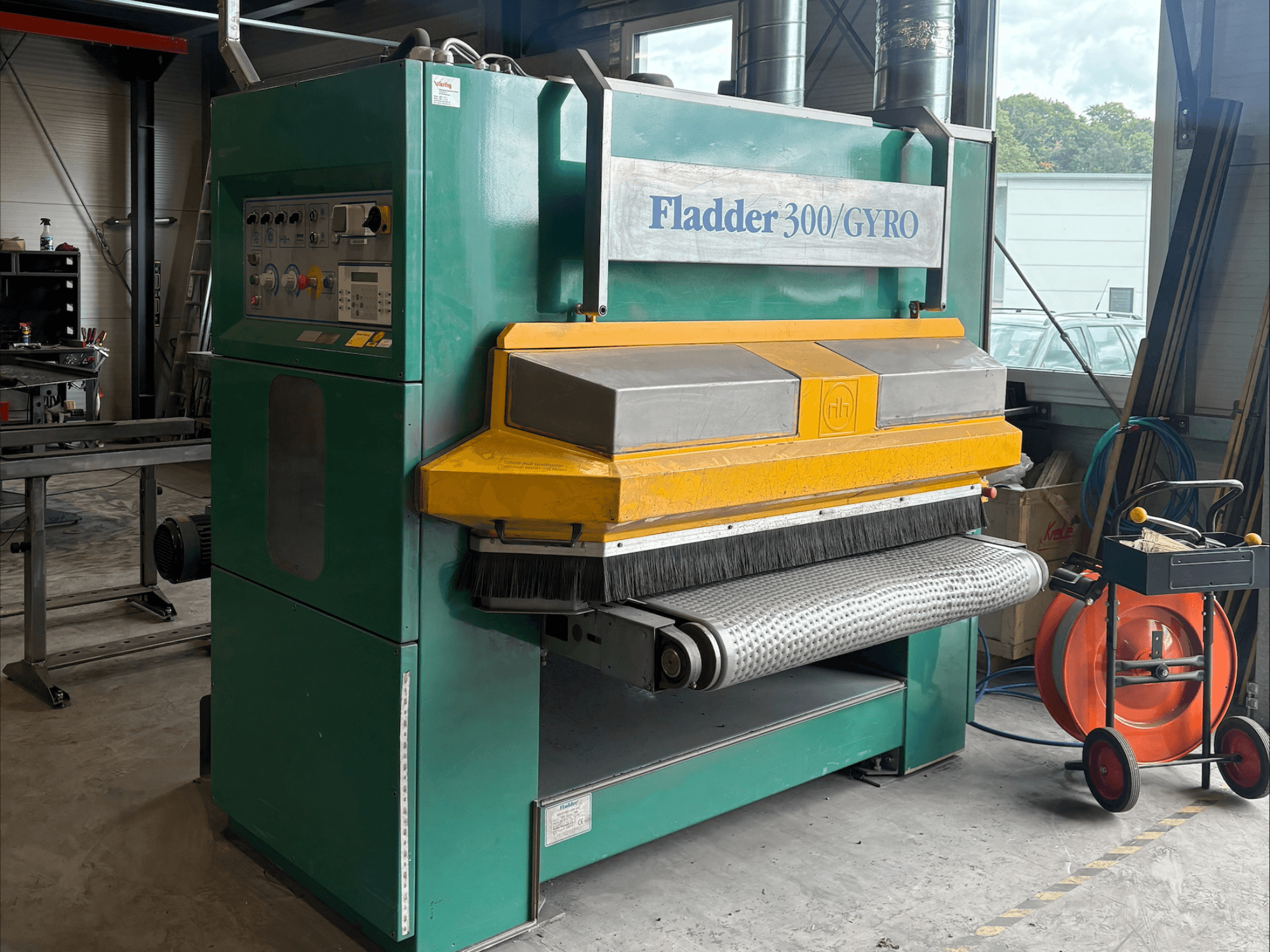 Промислова шліфувальна машина Fladder 300/GYRO в зелено-жовтому кольорі, вид спереду, з панеллю керування та шліфувальним барабаном.