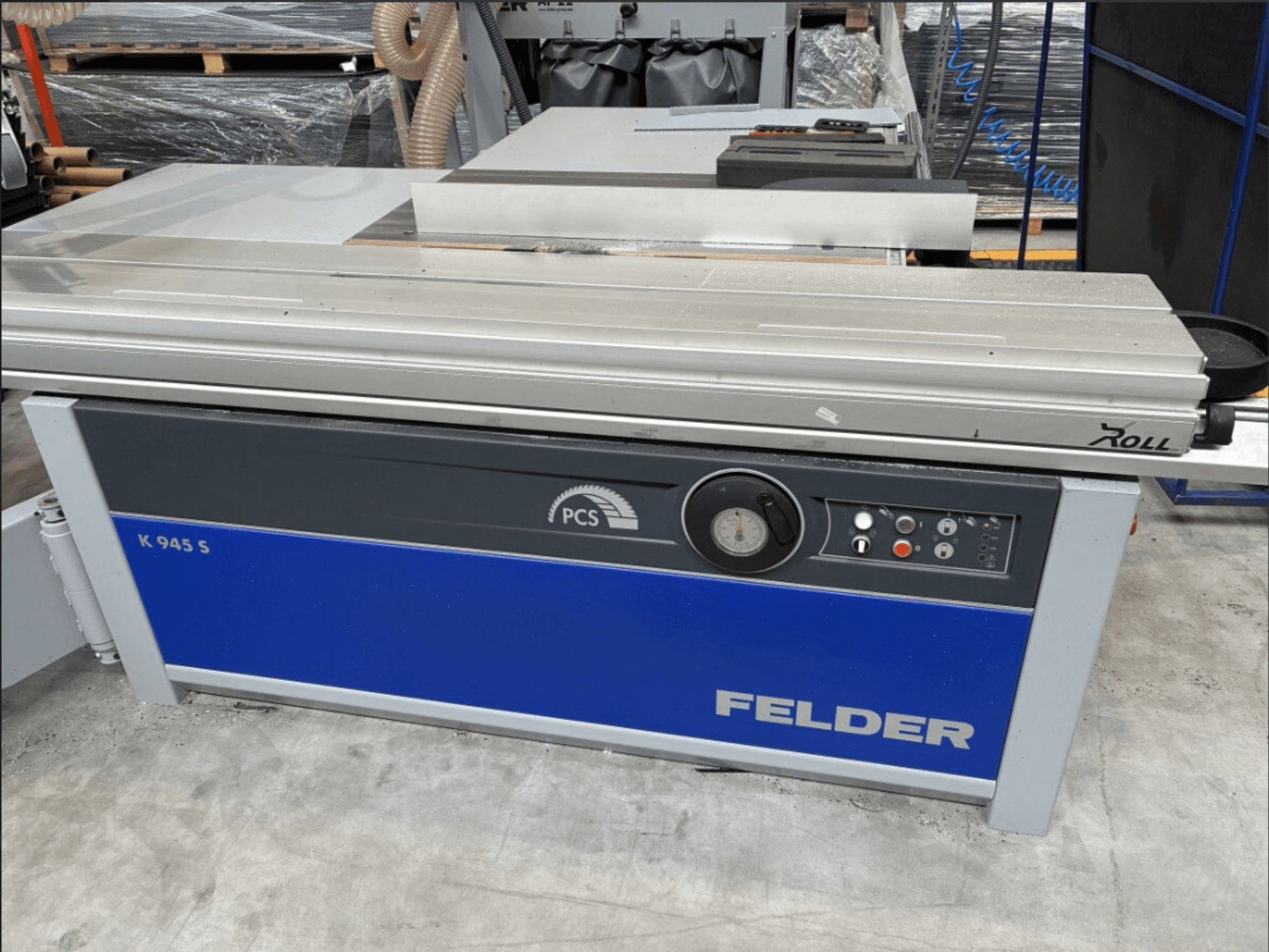 Пила для розпилювання плит FELDER K 945 S, вид спереду, на якому видно панель управління, стіл та захисні пристрої; встановлена на підлозі майстерні.