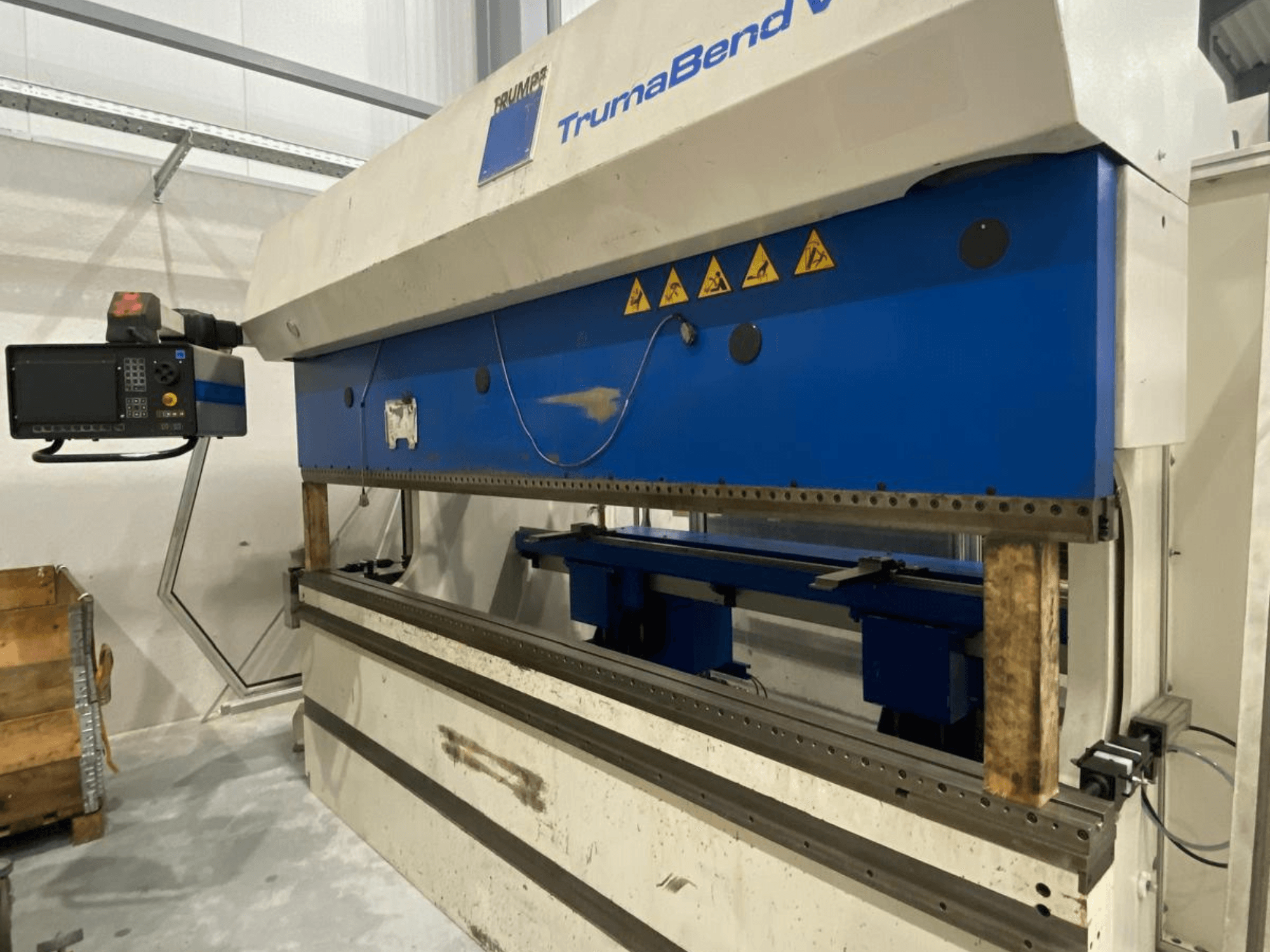 Гнучкий прес TRUMPF Trumabend V130, вид спереду, з панеллю керування, синіми елементами та видимими попереджувальними наклейками.