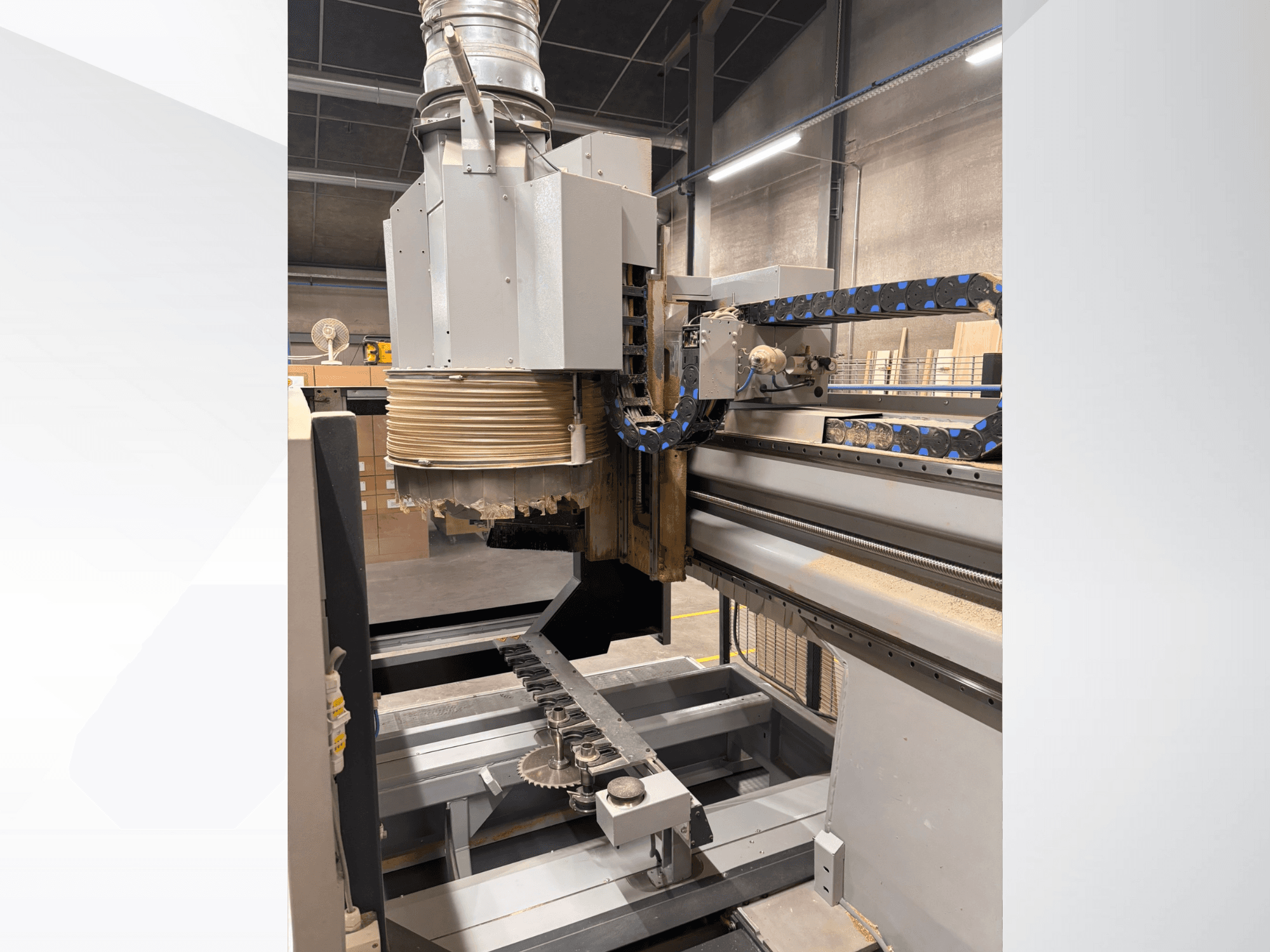 Фрезерний верстат з ЧПУ з великим шпинделем і конвеєром, вид збоку, демонструє дереворізальні інструменти та компоненти верстата.