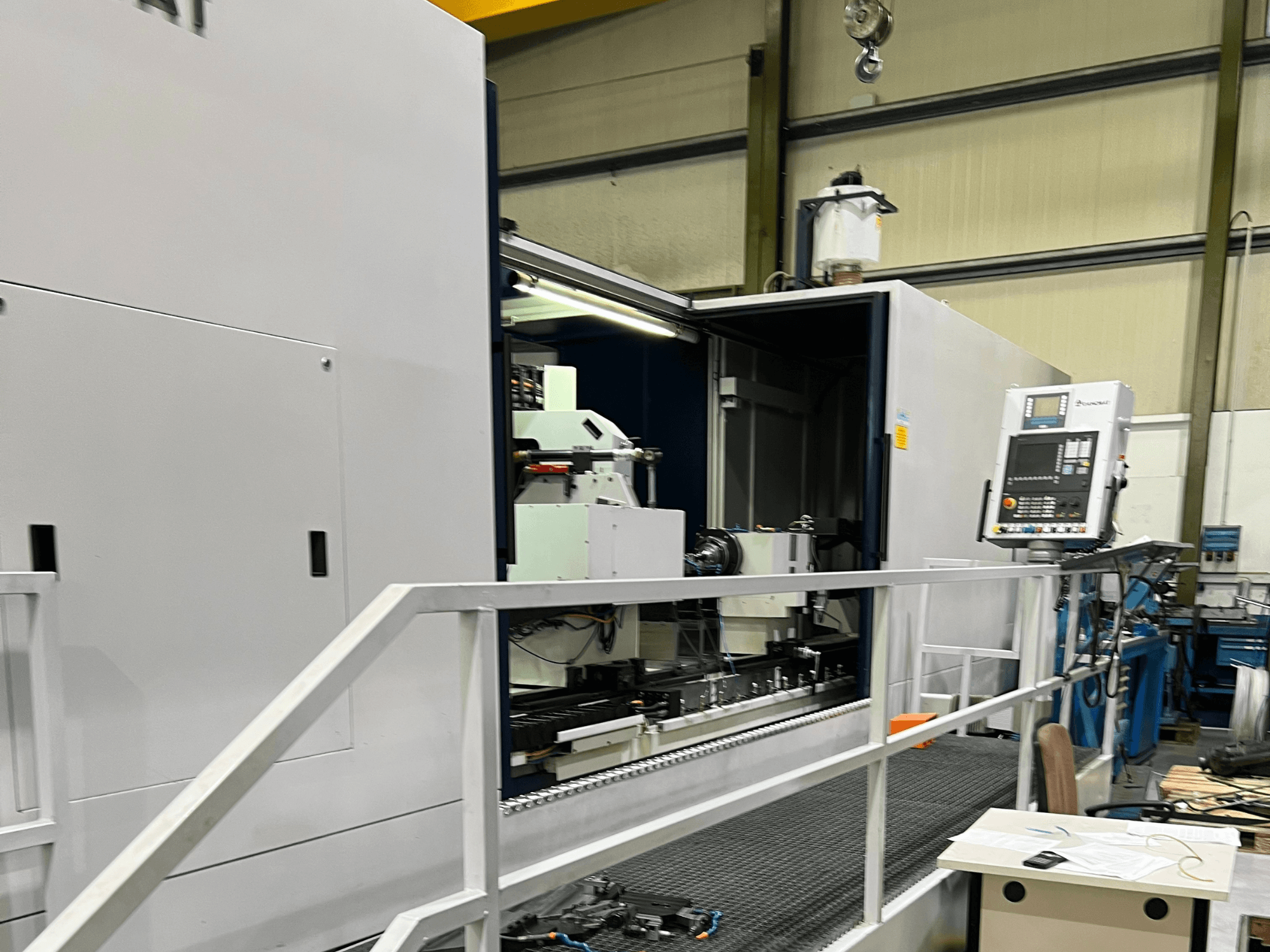 Обробний центр з ЧПК з відкритим видом збоку, що демонструє елементи керування, тримач інструменту та основний компонент всередині. Деталі бренду не видно.