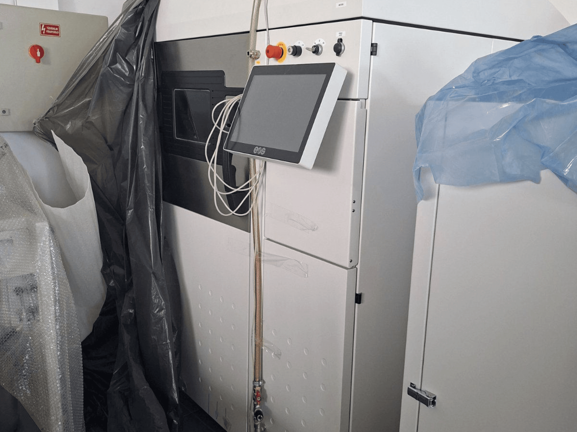 Металевий 3D-принтер EOS M 290 спереду, з сенсорним екраном, панеллю керування та захисним покриттям.