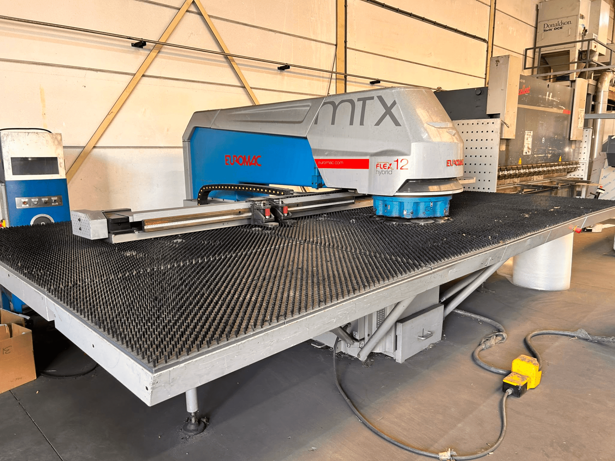 Штампувальний верстат з ЧПУ Euromac MTX FLEX 12, вид спереду, з великим перфорованим столом та панеллю керування.