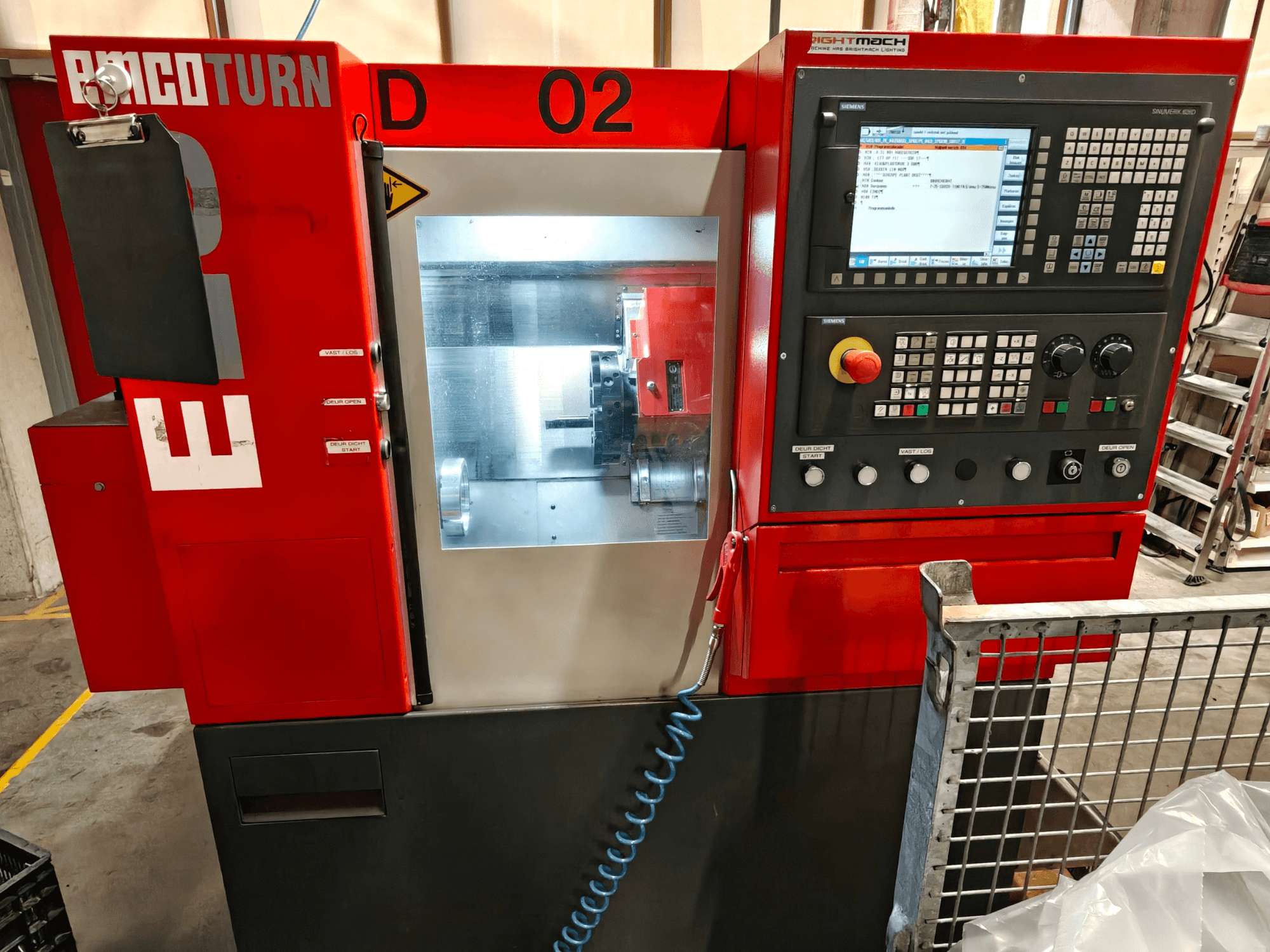 Вигляд спереду горизонтального токарного верстата EMCO TURN E25, на якому видно панель управління, екран дисплея та зону обробки.