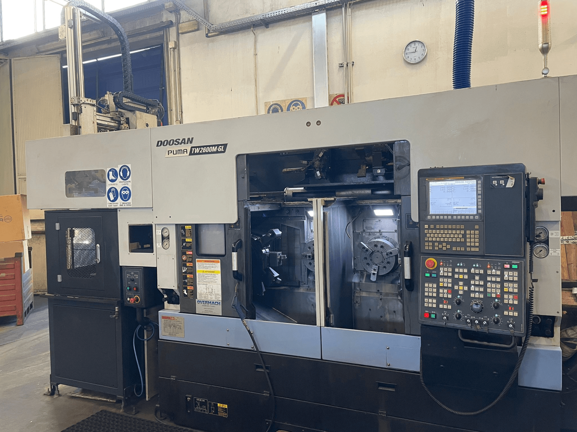 Токарний верстат Doosan Puma TW2600M GL з ЧПУ, вид спереду, демонструє цифрову панель керування та внутрішню частину верстата з тримачами для інструментів.