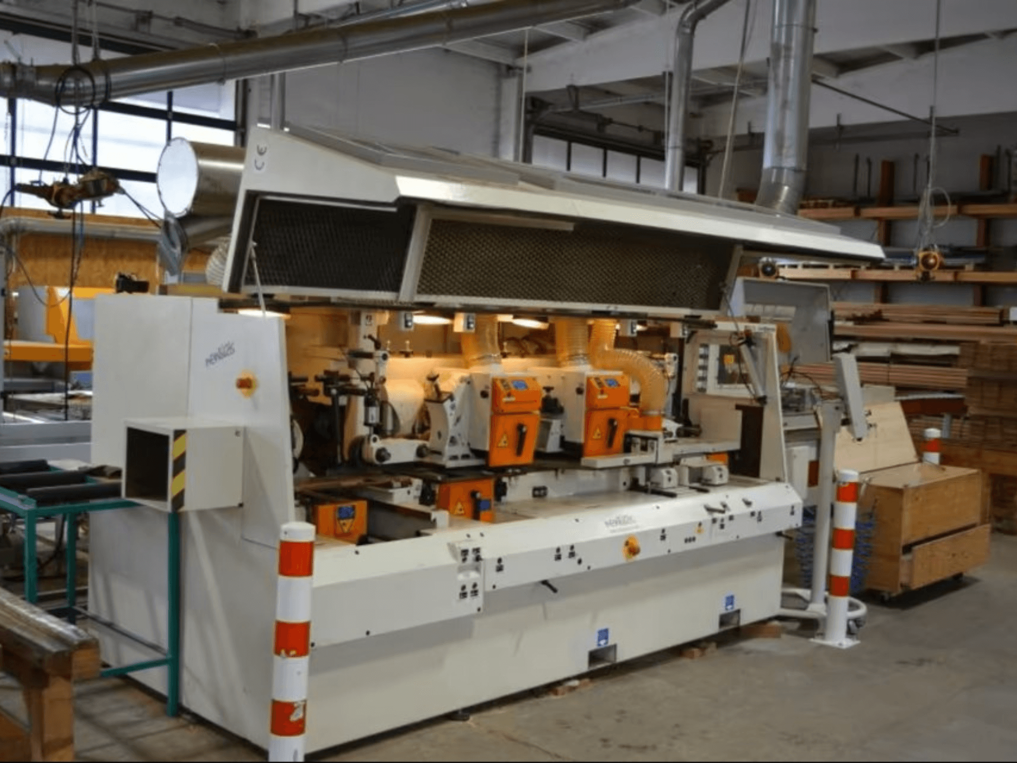 Деревообробний верстат PENIGAS, вид спереду, з двома помаранчевими ріжучими головками та системою відсмоктування пилу в умовах майстерні.