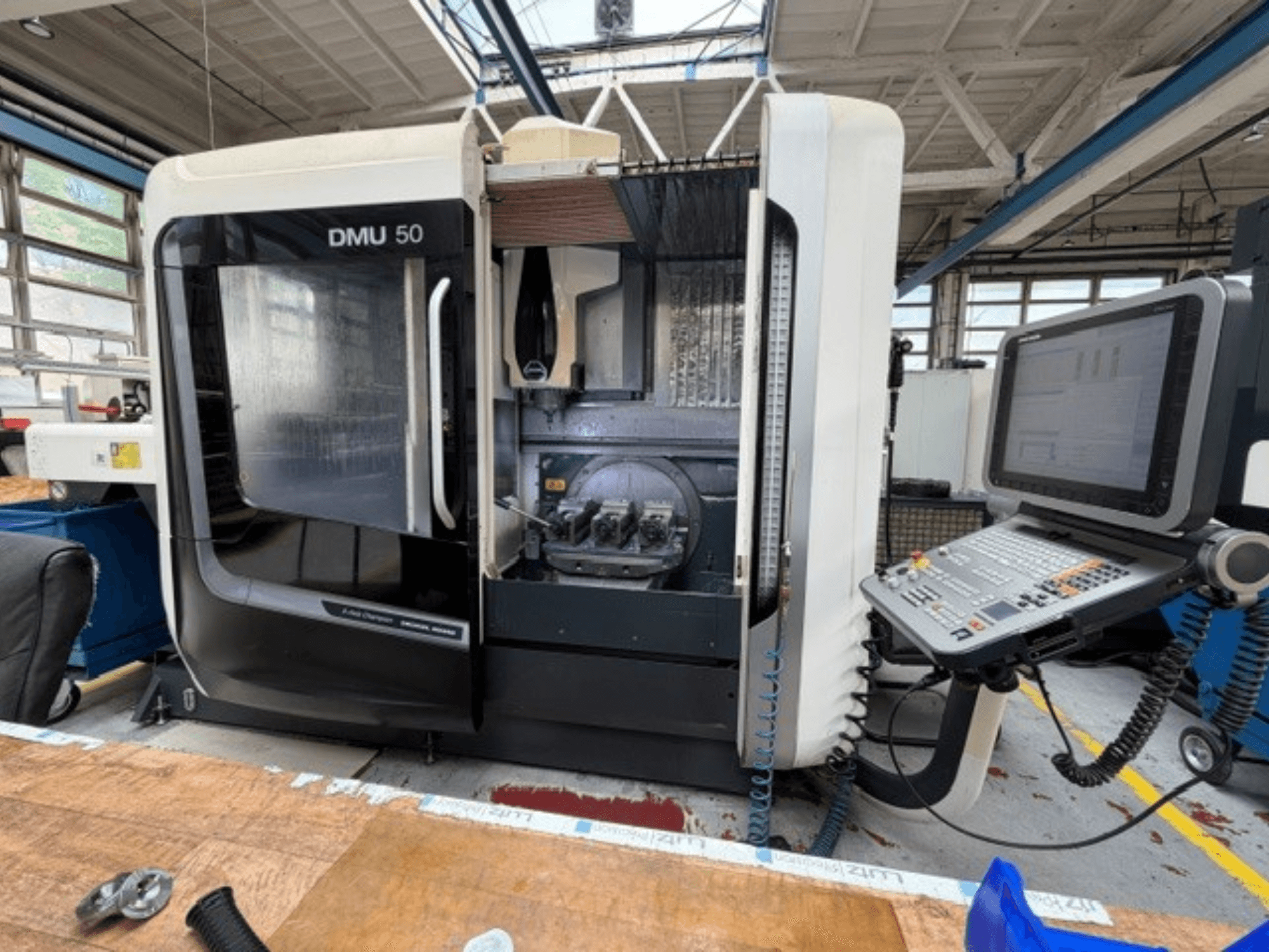Вертикальний обробний центр DMG MORI DMU 50 3-го покоління, зображений спереду, з відкритими дверцятами, з видимою панеллю ЧПУ та робочою зоною всередині.