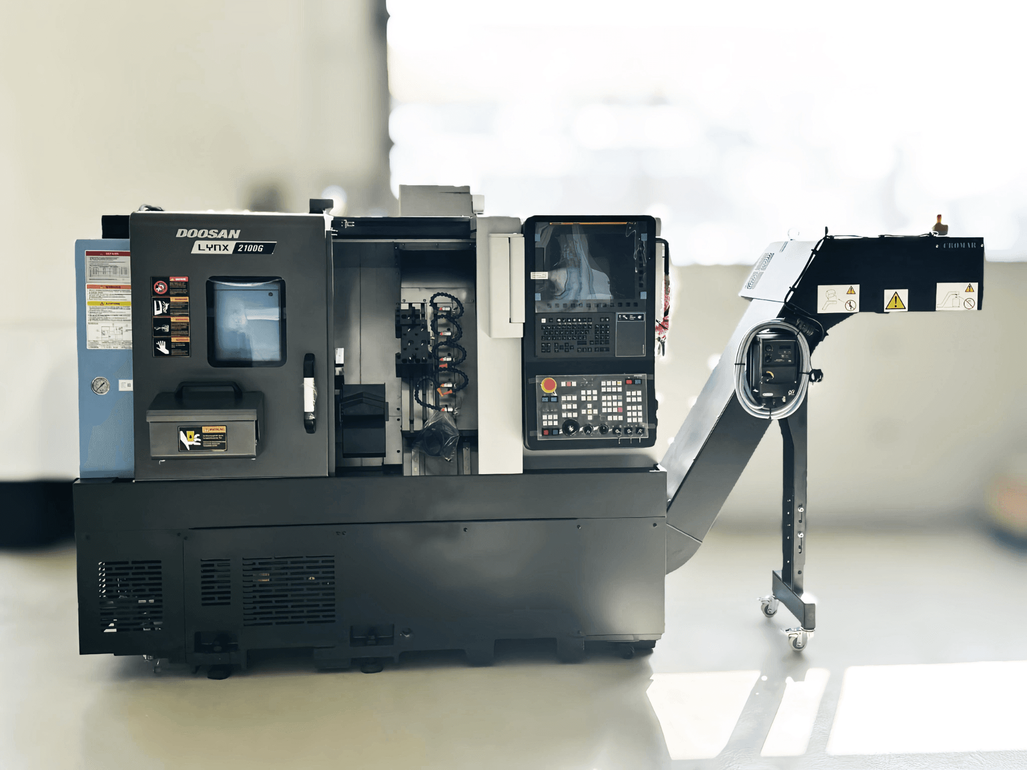 Токарний верстат DOOSAN LYNX 2100GA швейцарського типу збоку, видно панель керування та тримач інструменту.