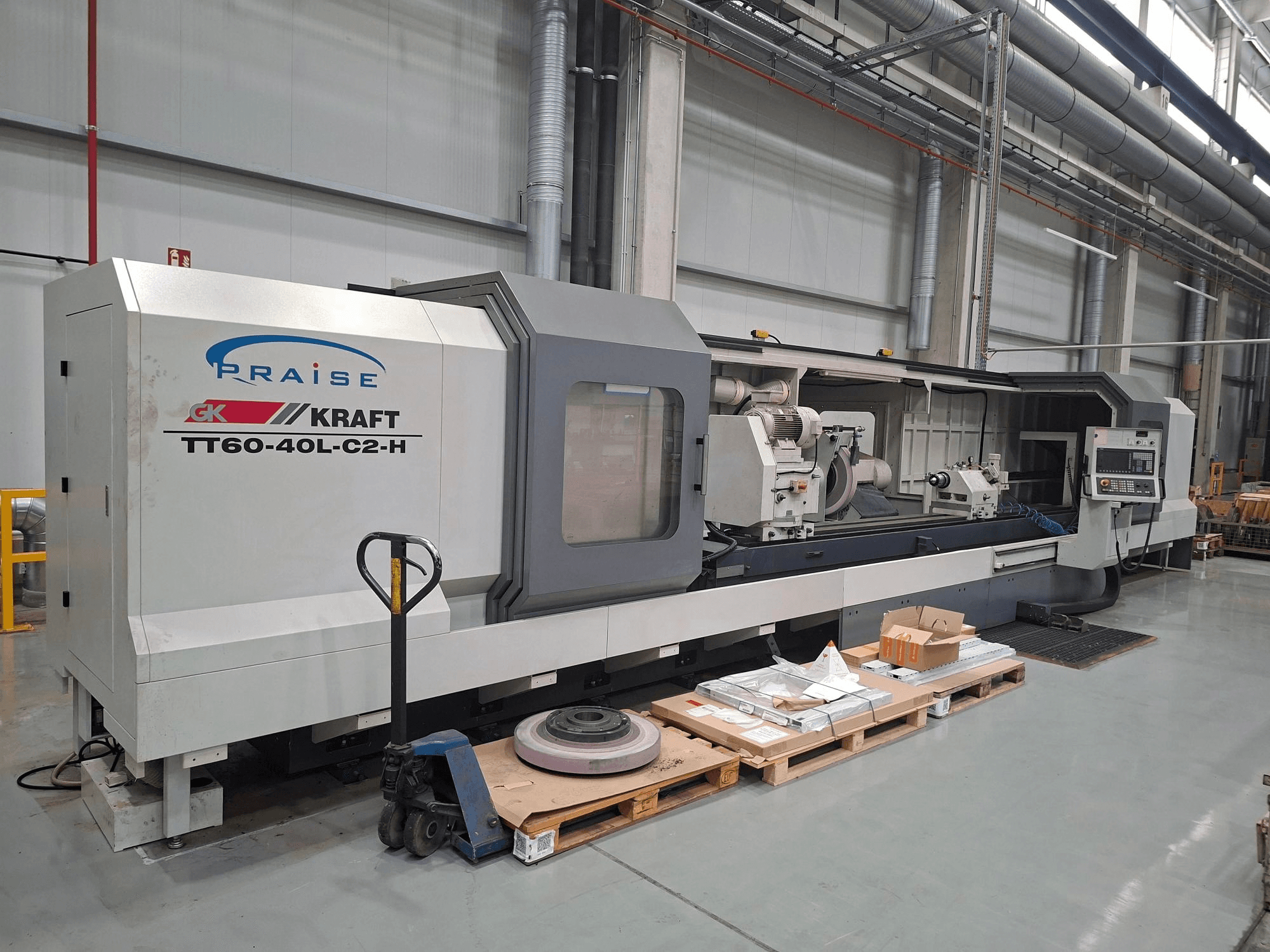 Циліндричний шліфувальний верстат KRAFT TT60-40L-C2-H, вид збоку, на якому показані органи управління та шліфувальний круг у цехових умовах.