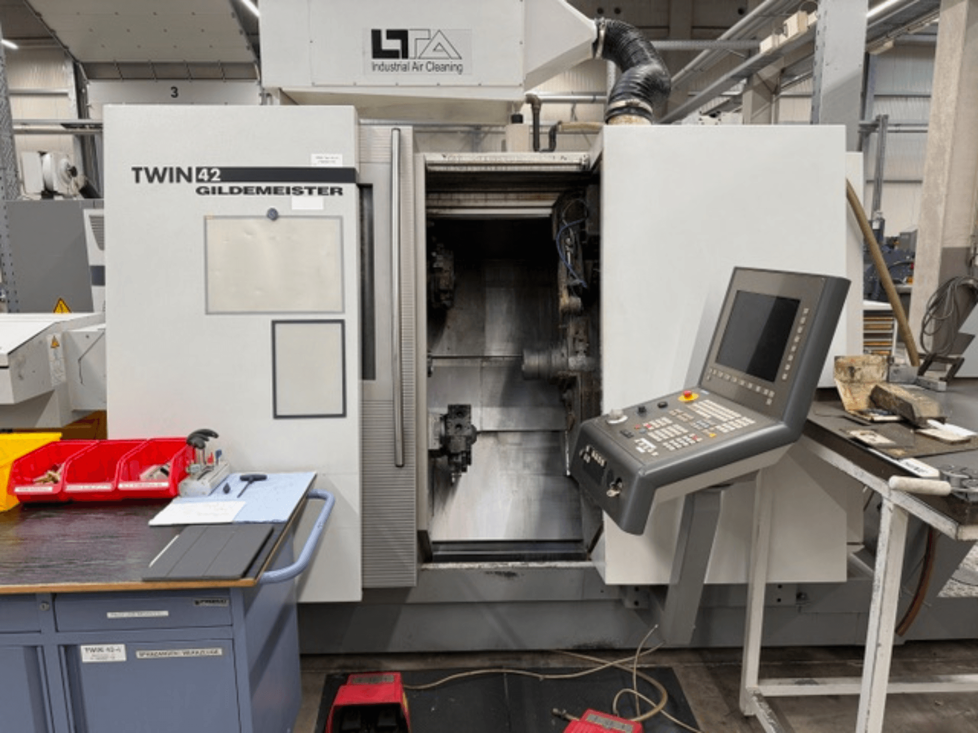 Горизонтальний токарний верстат Gildemeister TWIN 42, вид спереду, на якому видно панель управління та відкриту робочу зону.