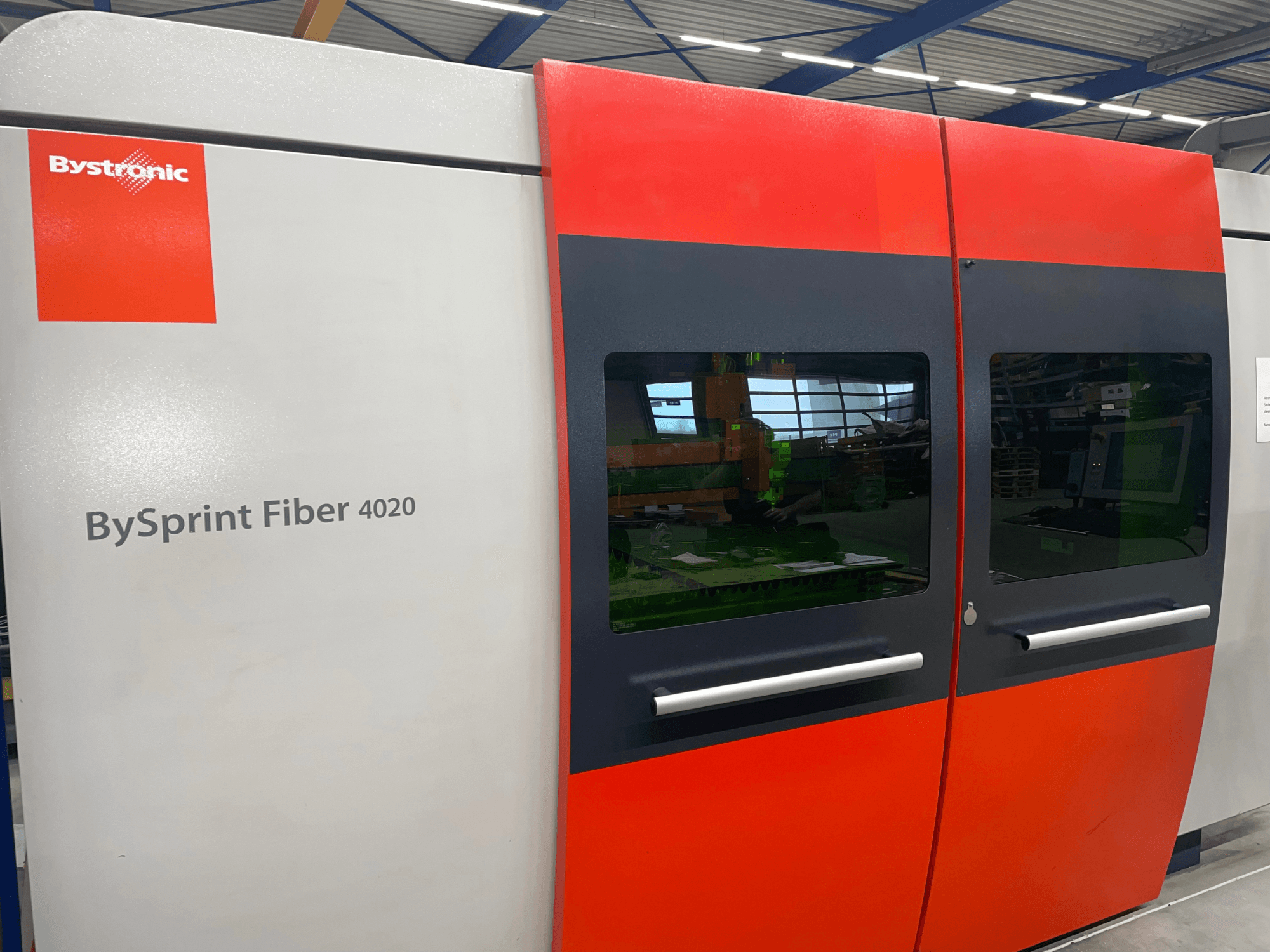 Bystronic BySprint Fiber 4020 спереду, з сіро-червоною панеллю з великими вікнами та інтерфейсом керування всередині.