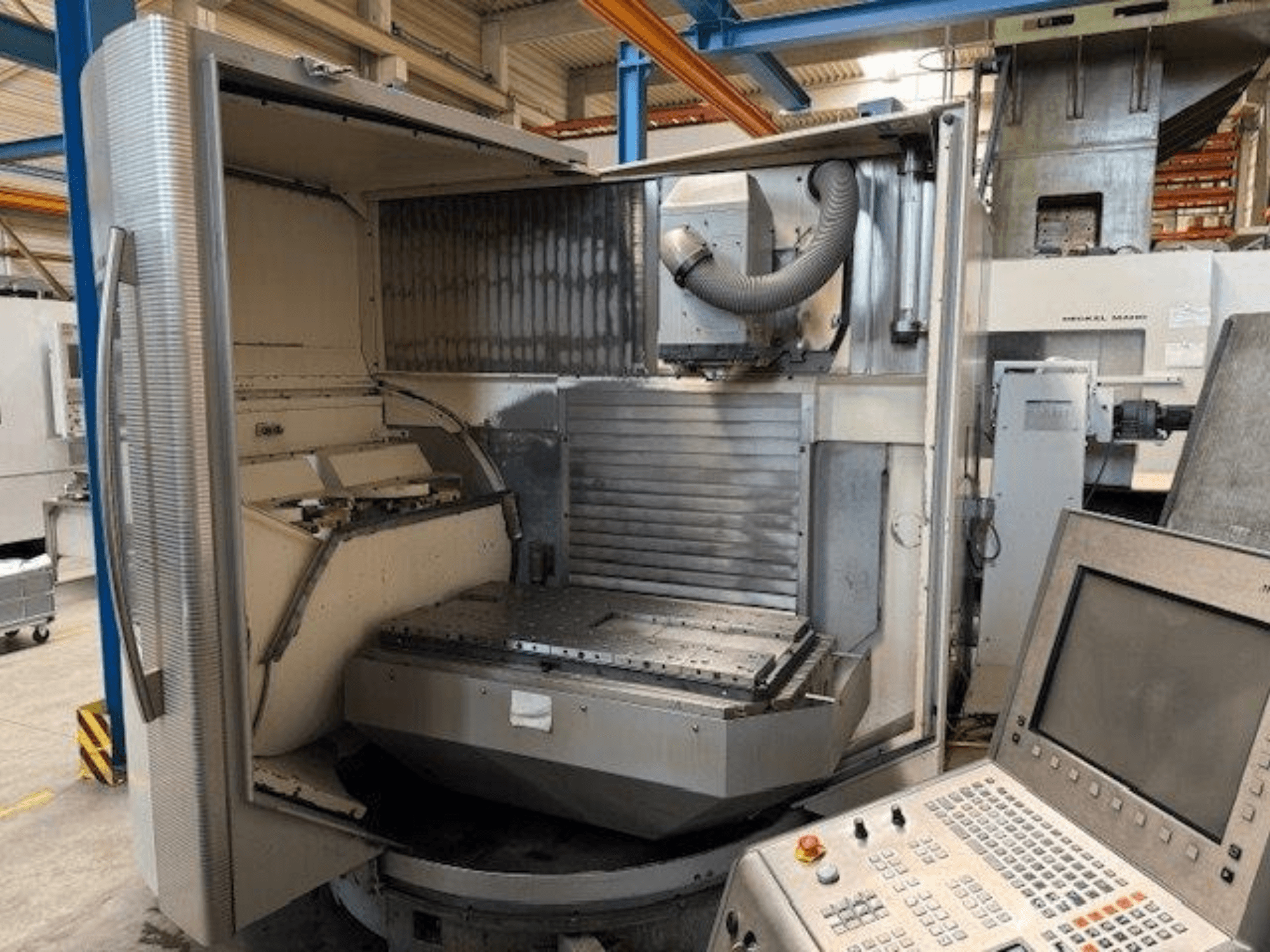 Вертикальний обробний центр DMG MORI DMU 80T, вид спереду з відкритим корпусом і панеллю керування.