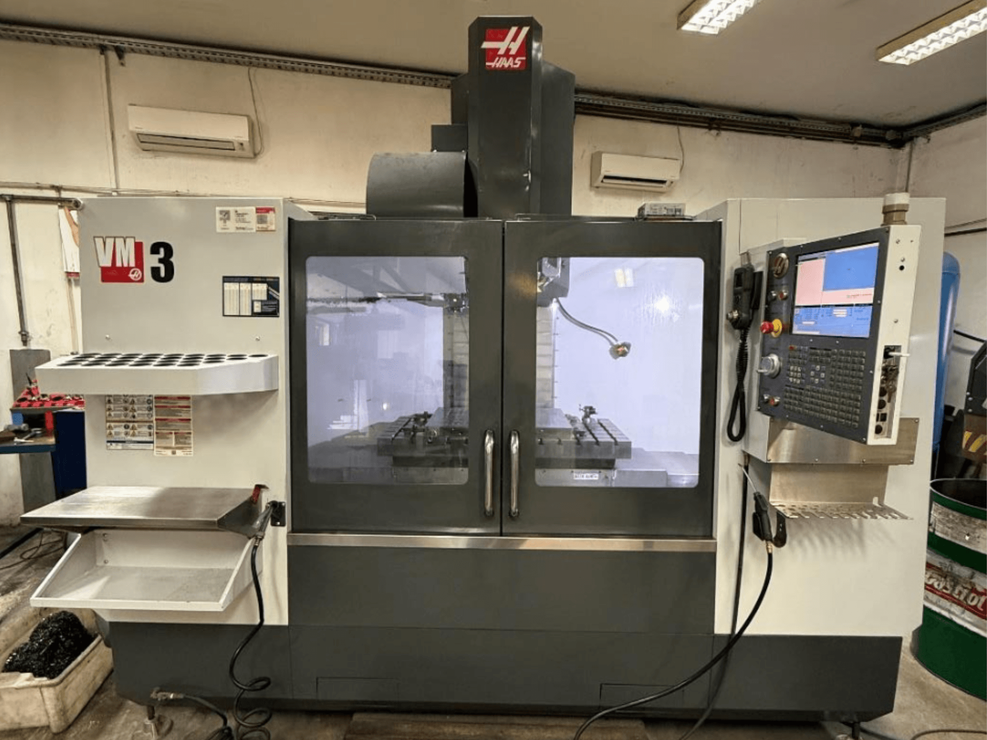 Вертикальний обробний центр Haas VM-3 у фронтальному ракурсі, з великою панеллю керування та хорошою оглядовістю робочої зони з інструментами.