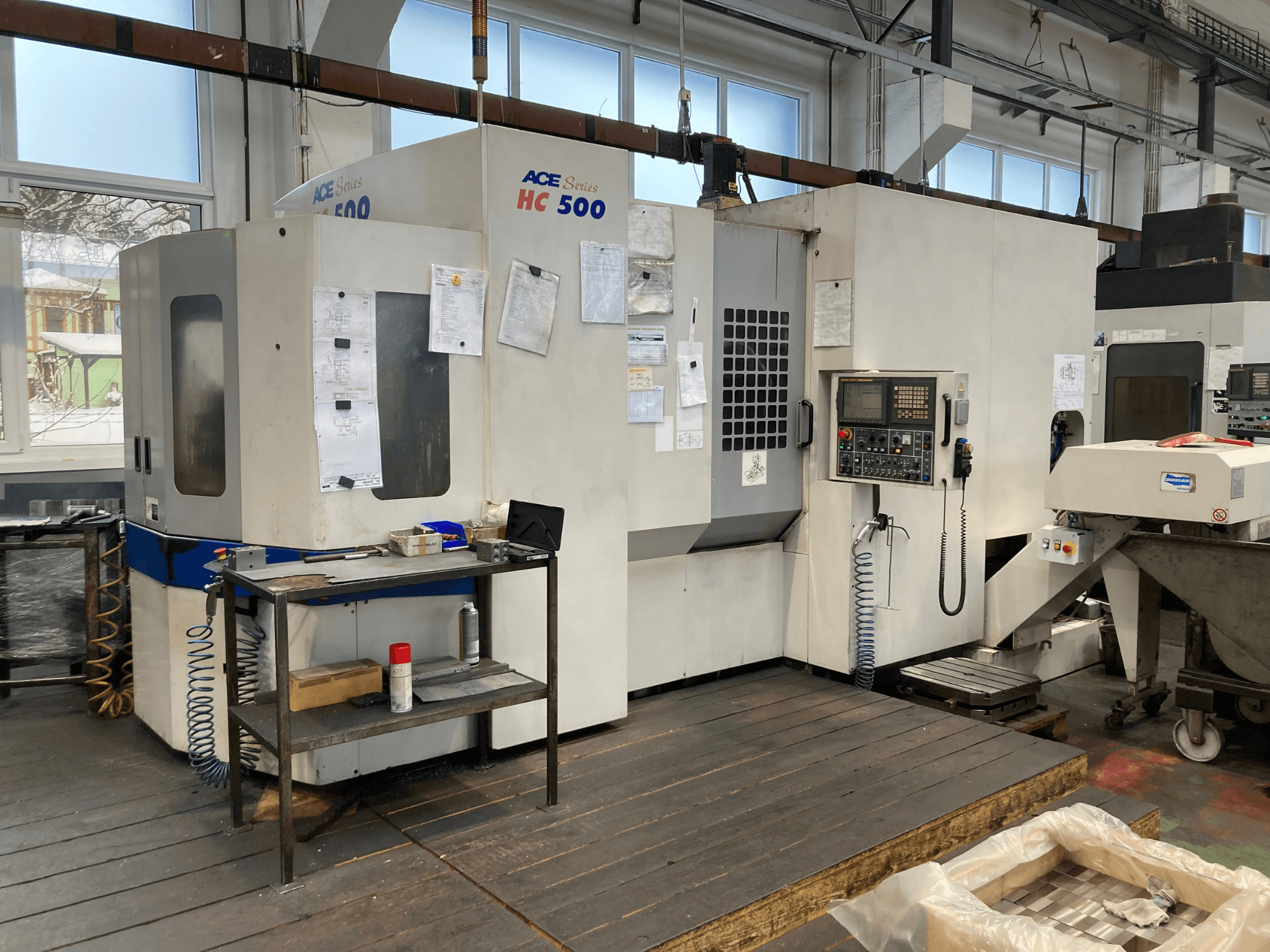 Горизонтальний обробний центр DOOSAN ACE HC-500, вид спереду; оснащений панеллю керування, накопичувачем для декількох інструментів і промисловим налаштуванням.