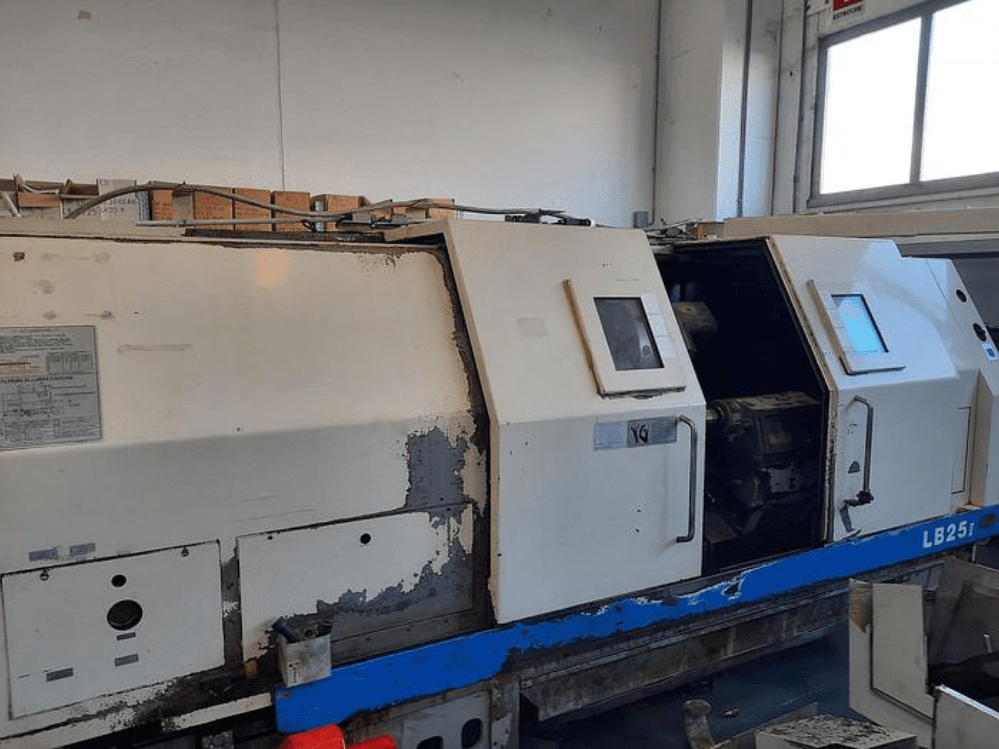 Токарний верстат LB251, що був у вжитку, вид збоку, видно зношений зовнішній вигляд, відкрита панель показує внутрішній механізм та елементи керування.