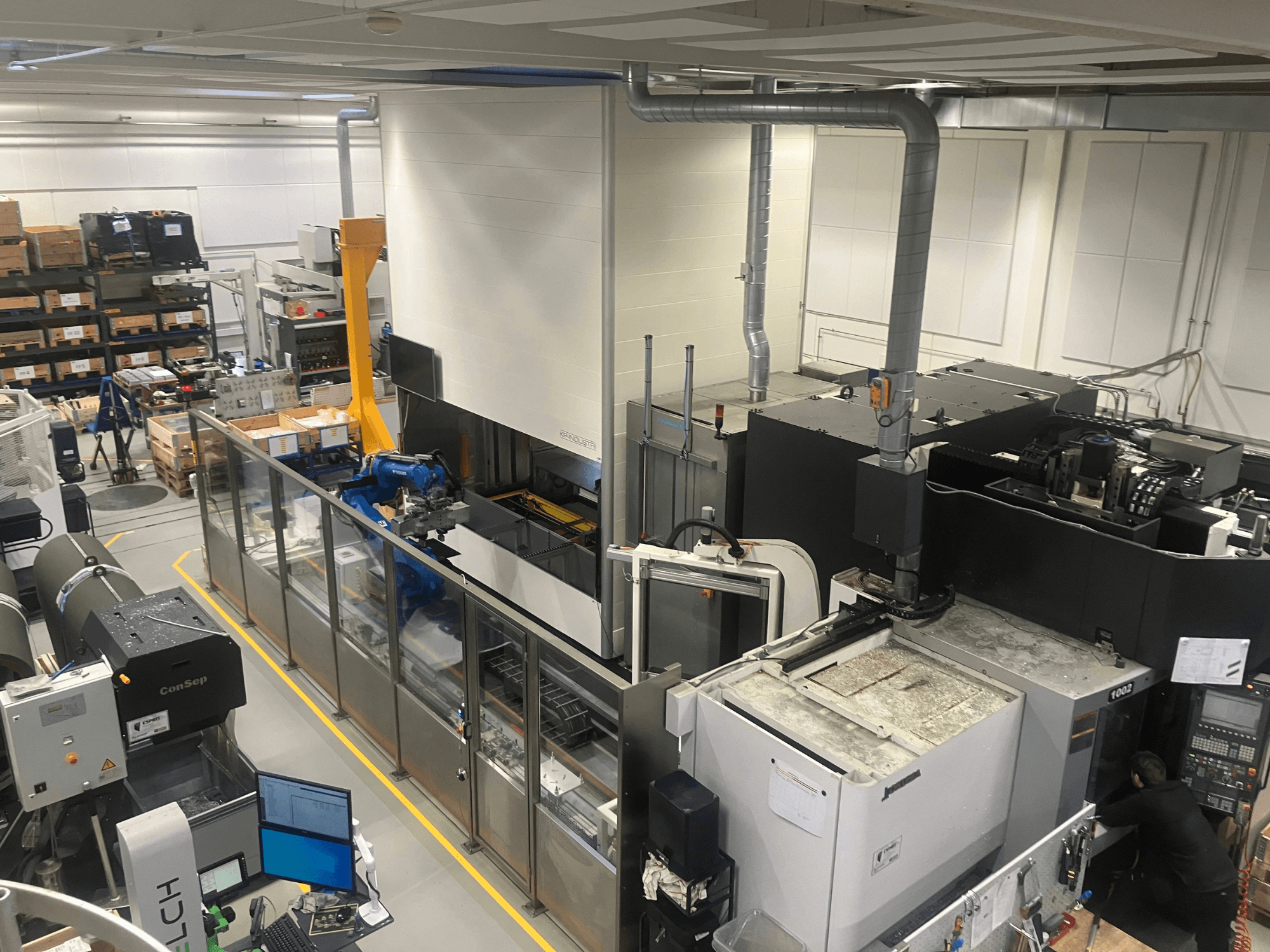 Система автоматизації SSI SCHAFER Logimat на складі, вид спереду; включає роботизований маніпулятор, стелажі та механізми.