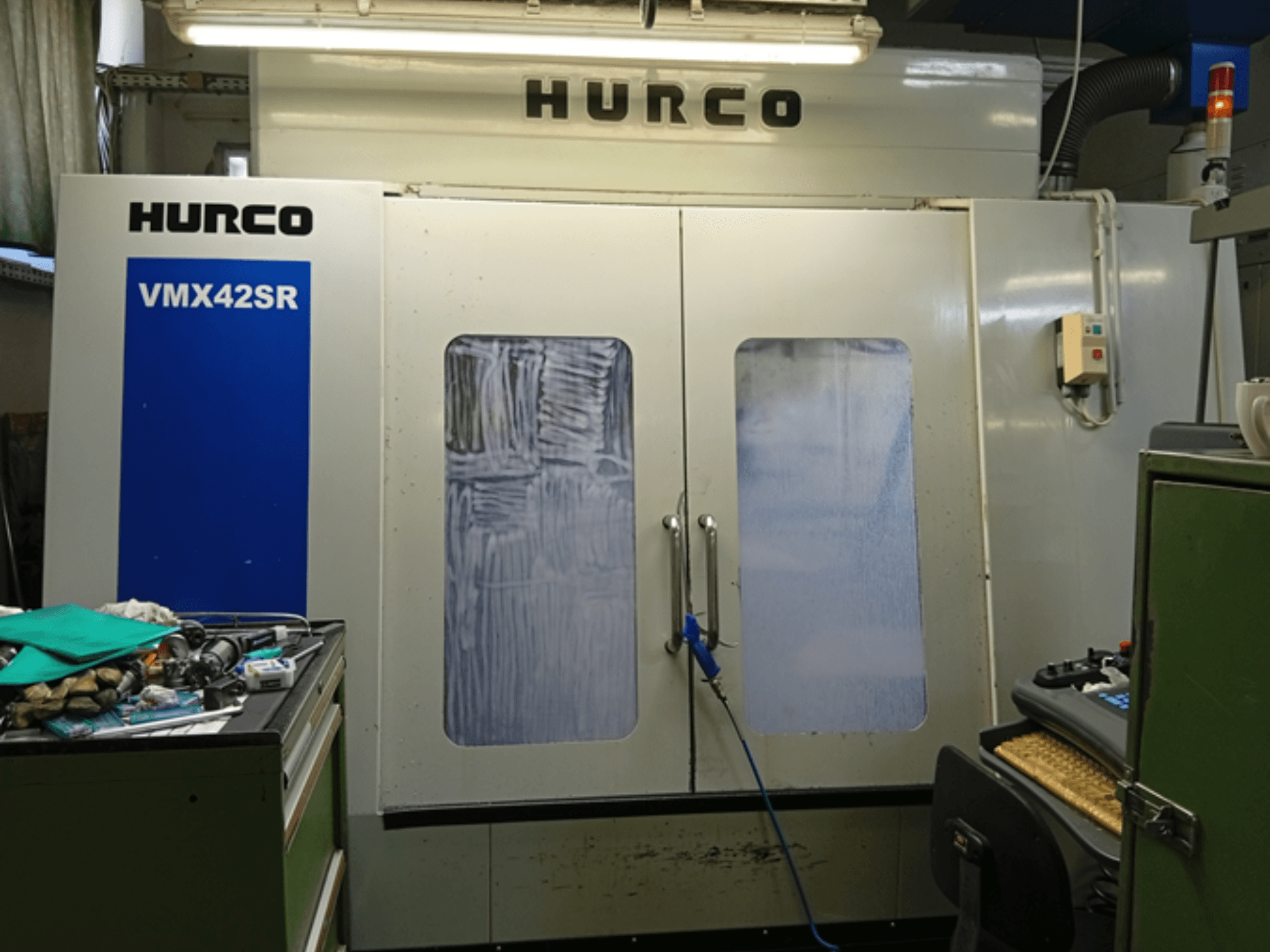 Вертикальний обробний центр Hurco VMX 42SR спереду, з синьою панеллю, інтерфейсом керування та чистим робочим простором.