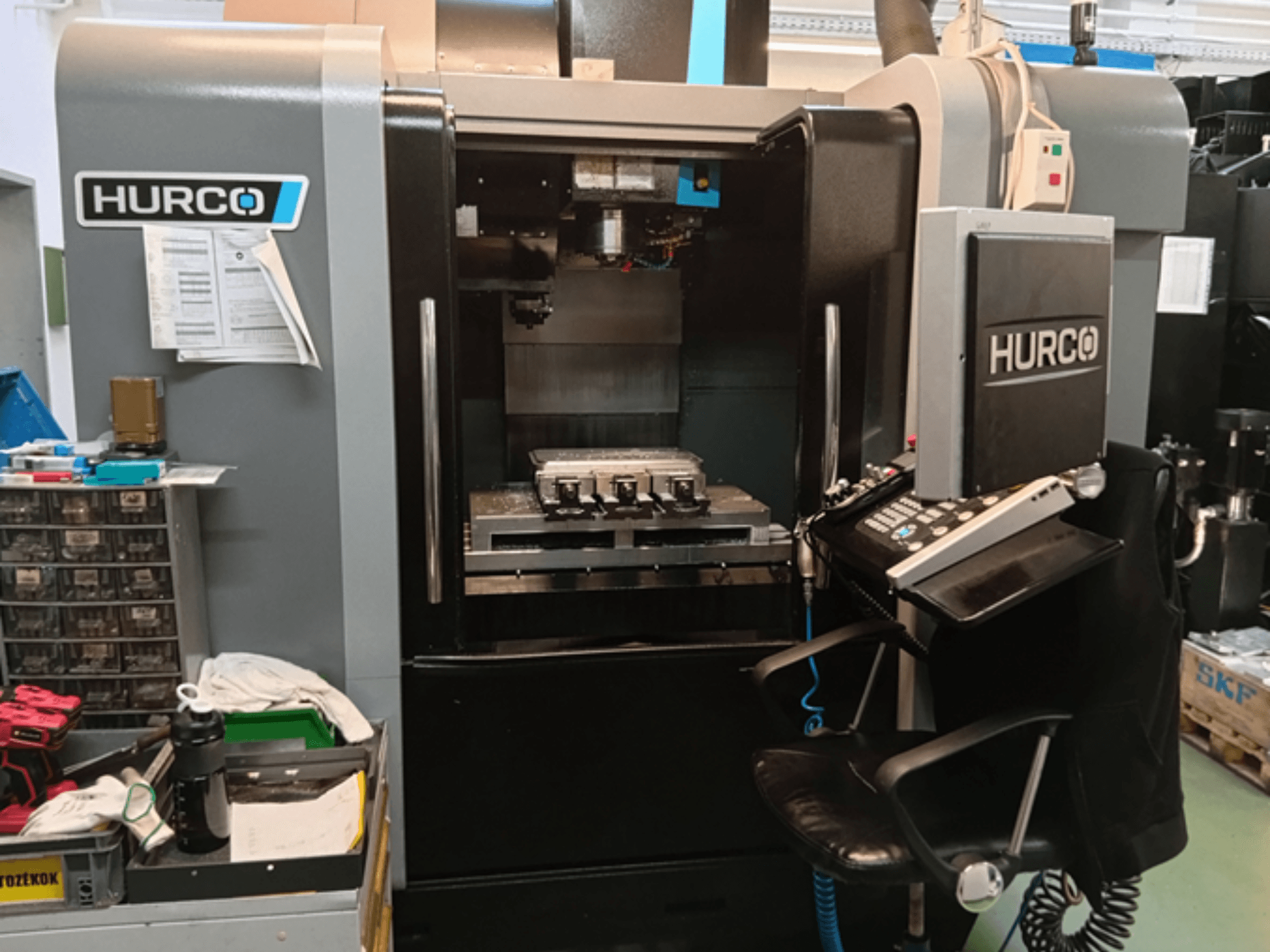 Вертикальний обробний центр Hurco VMX 30i спереду, з панеллю керування, робочим столом і робочим налаштуванням.
