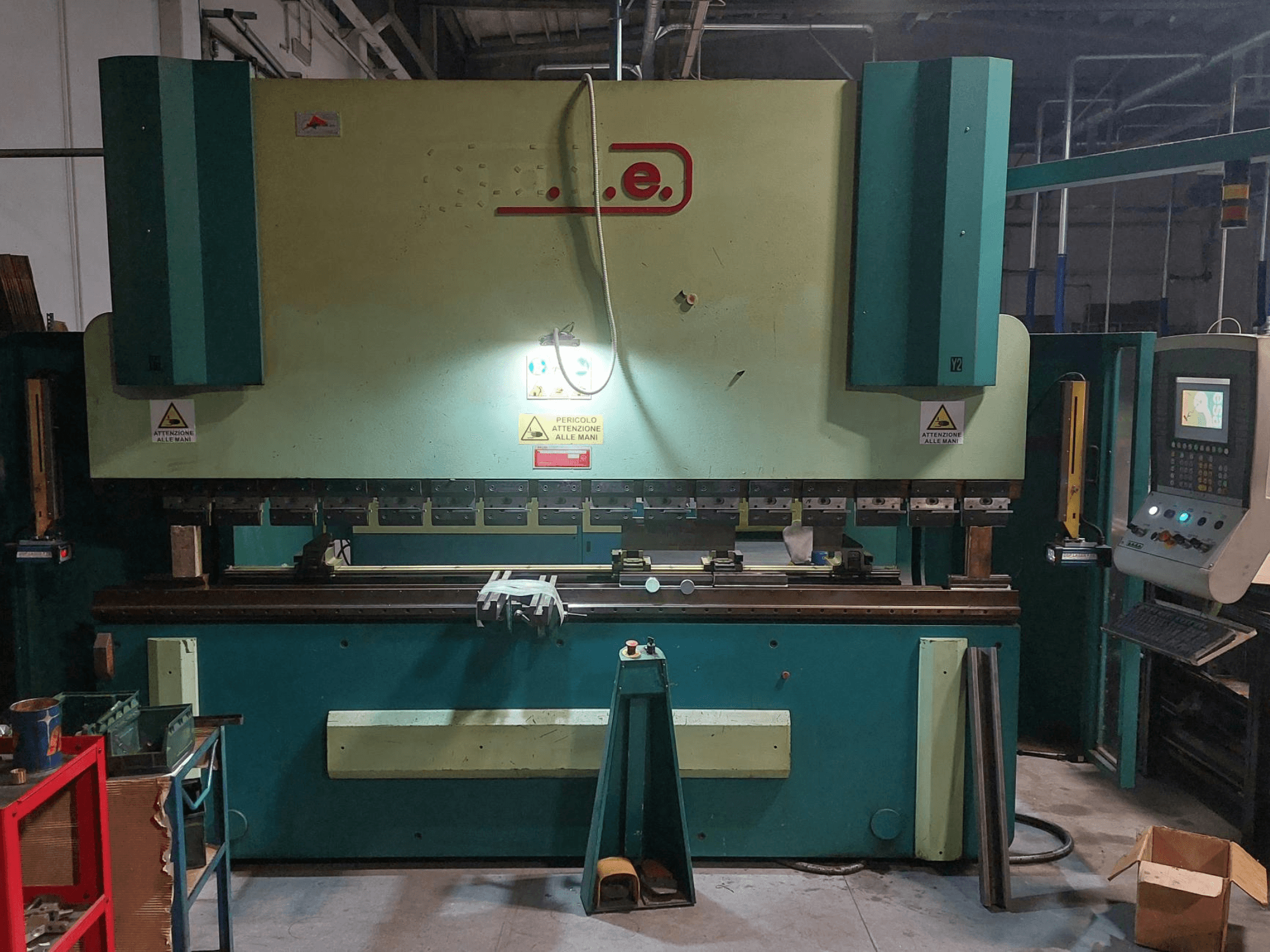 Вигляд спереду пресового згинального верстата Gade PS-C 3120 із панеллю керування, знаками безпеки та робочою зоною з інструментами та матеріалами.