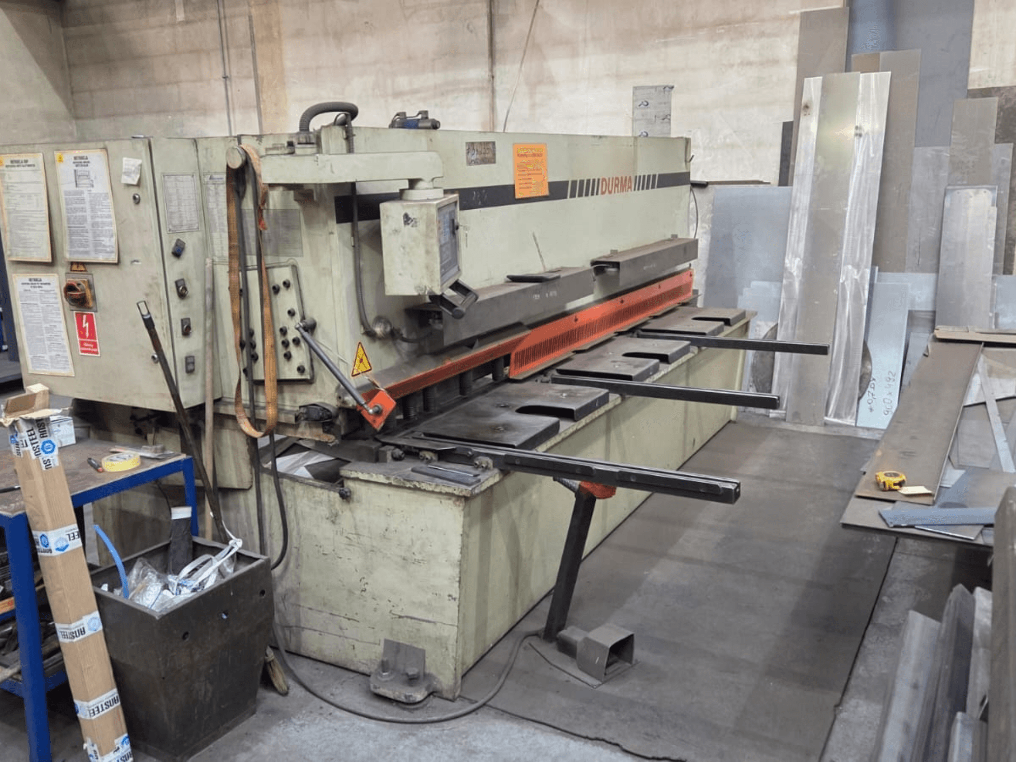 Гідравлічна ножична машина Durma SB 3060, вид спереду, з елементами керування, ріжучим ножем і металевими листами в робочому просторі.
