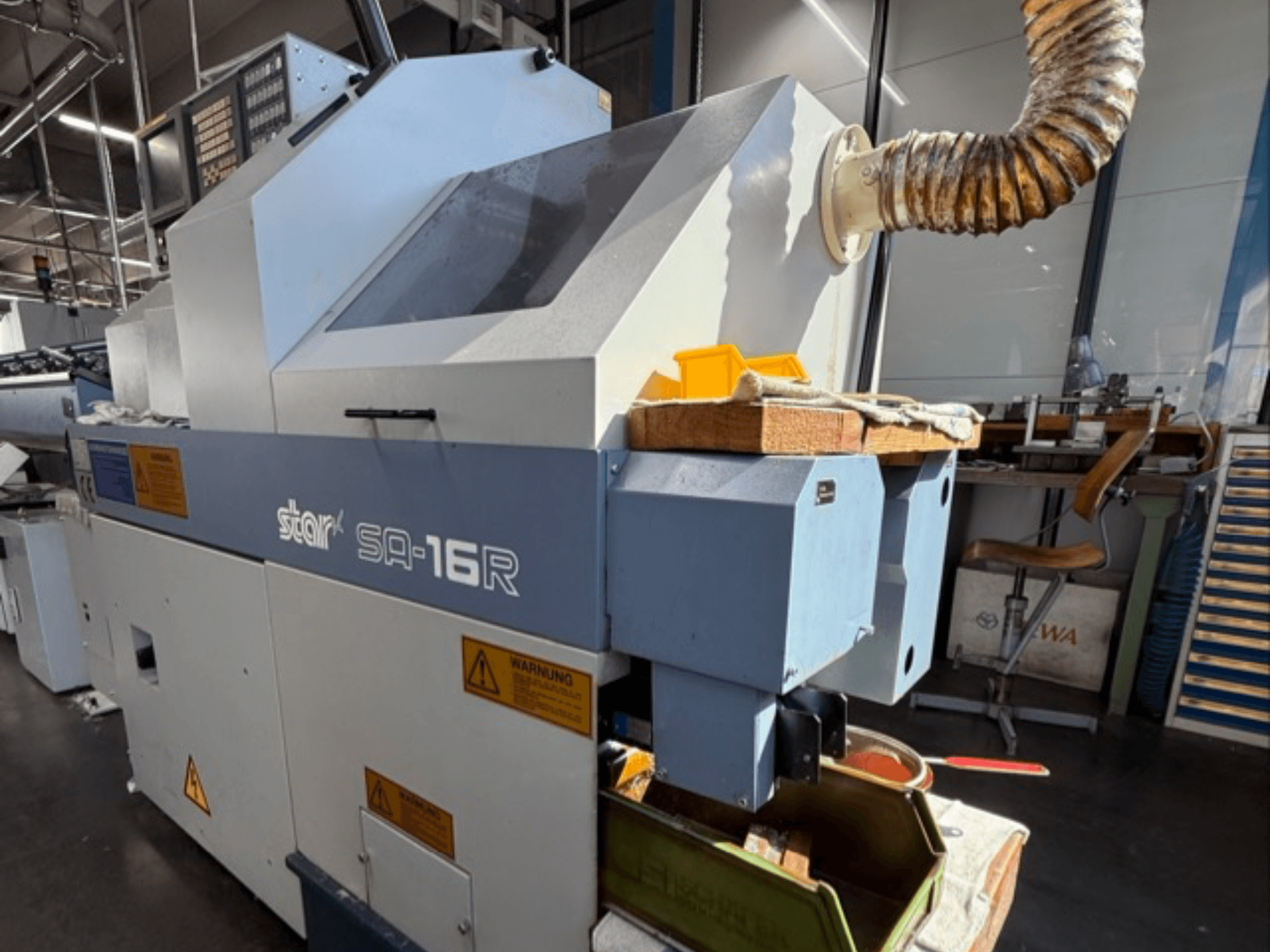 Машина Stark SA-16R, вид спереду, з конічним вихлопом і робочим простором з жовтими інструментами та попереджувальними етикетками.