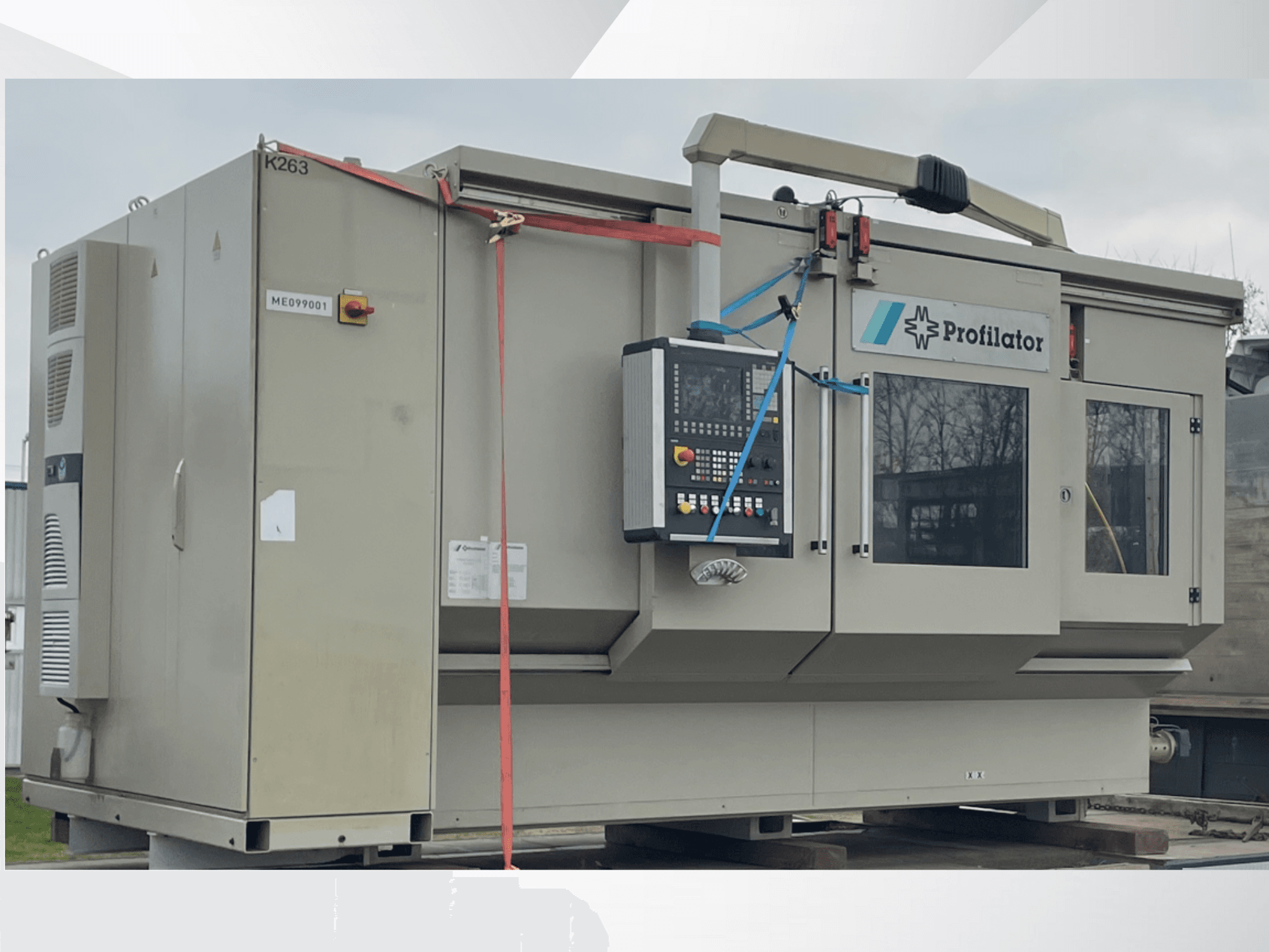 Профілювальний верстат збоку, з панеллю керування, етикетками безпеки та захисною обв'язкою на дерев'яній платформі.