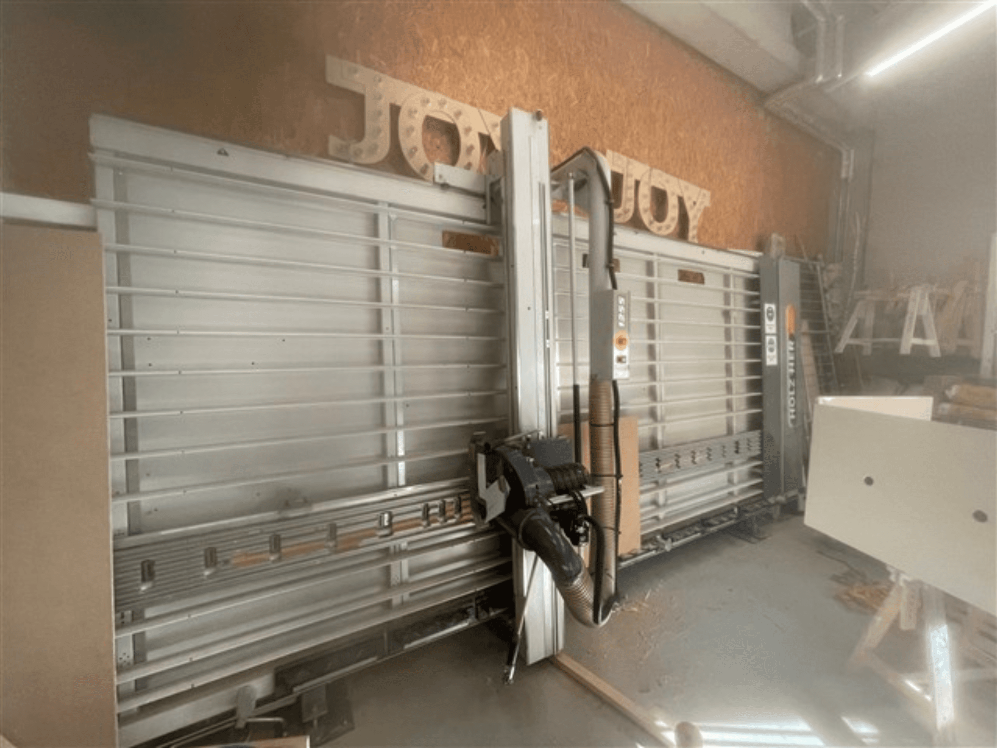 Горизонтальна панельна пила, марка Holz-Her, вид збоку, демонструє пильний диск, відсмоктування пилу та місце для зберігання.