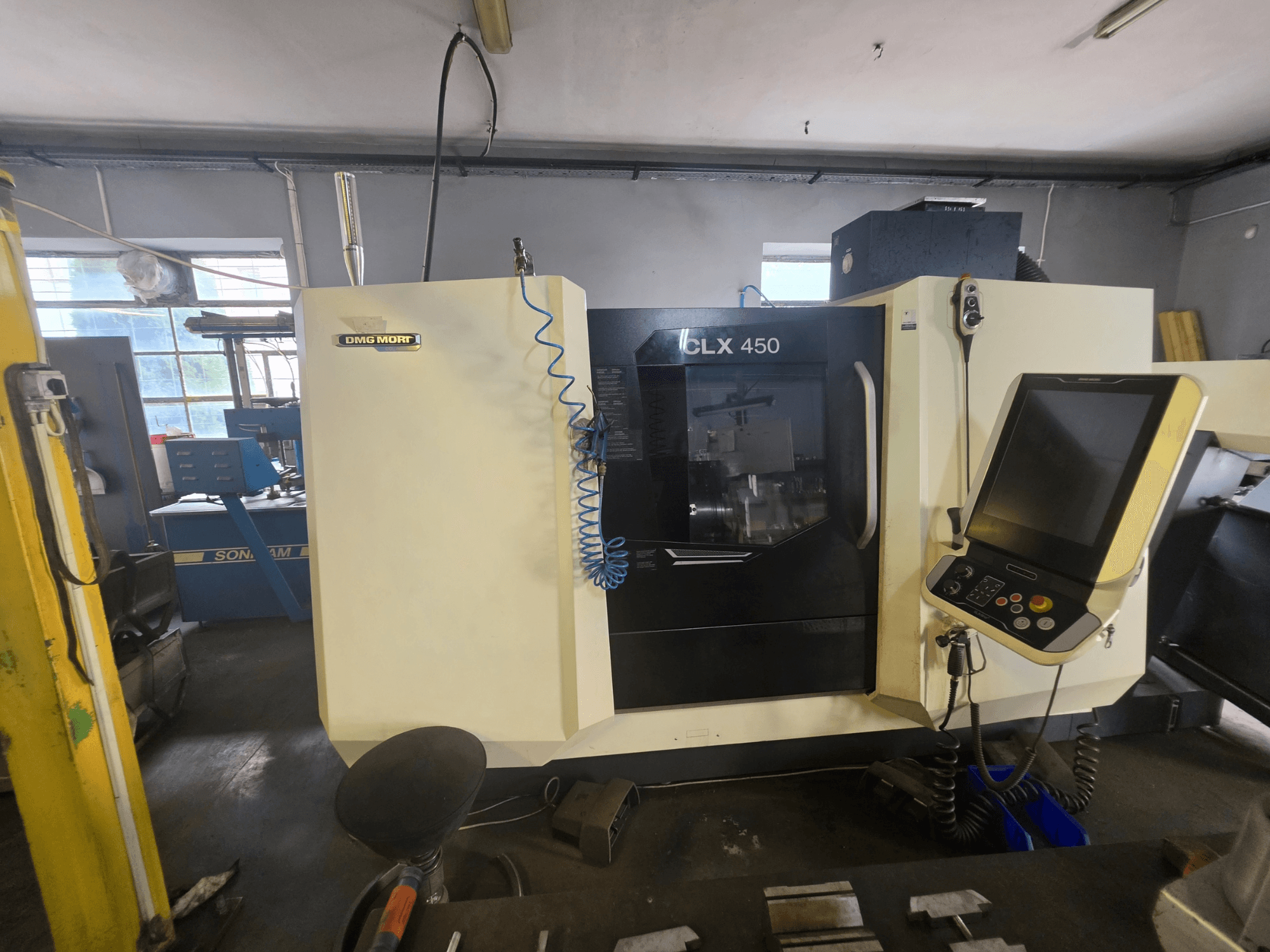 Горизонтальний токарний верстат DMG MORI CLX 450 V6 у фронтальному ракурсі, на якому видно панель управління та логотип виробника.