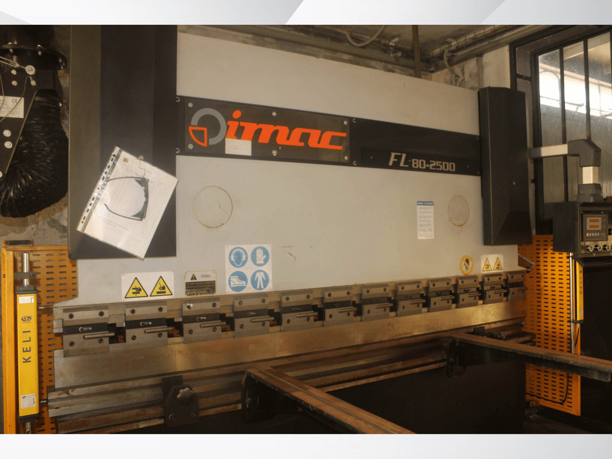 Згинальний верстат IMAC FL 80-2500, вид спереду, з панеллю керування, попередженнями про безпеку та металевими елементами оснащення.